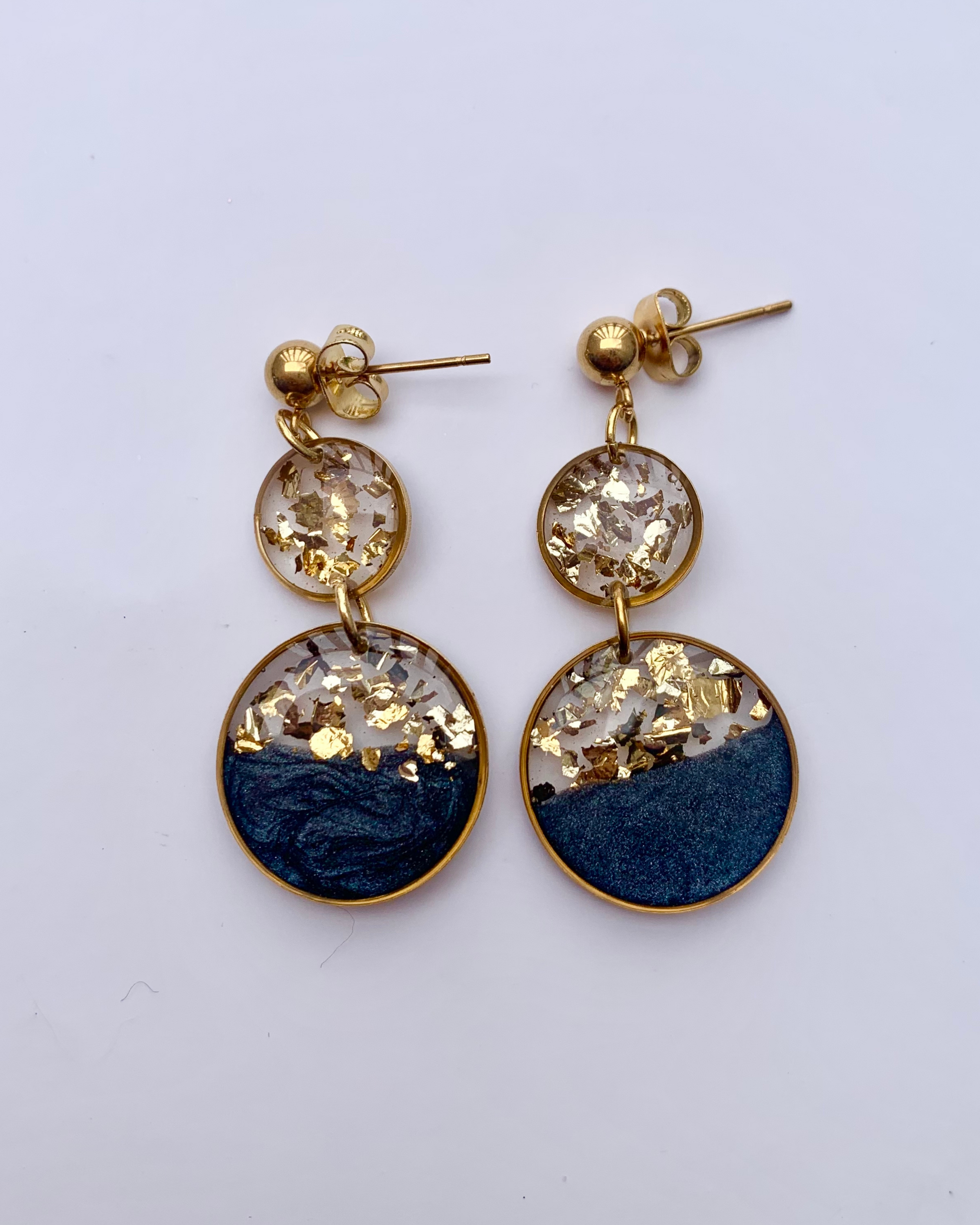 Una lujosa combinación de negro intenso, copos dorados brillantes y un elegante diseño de doble gota