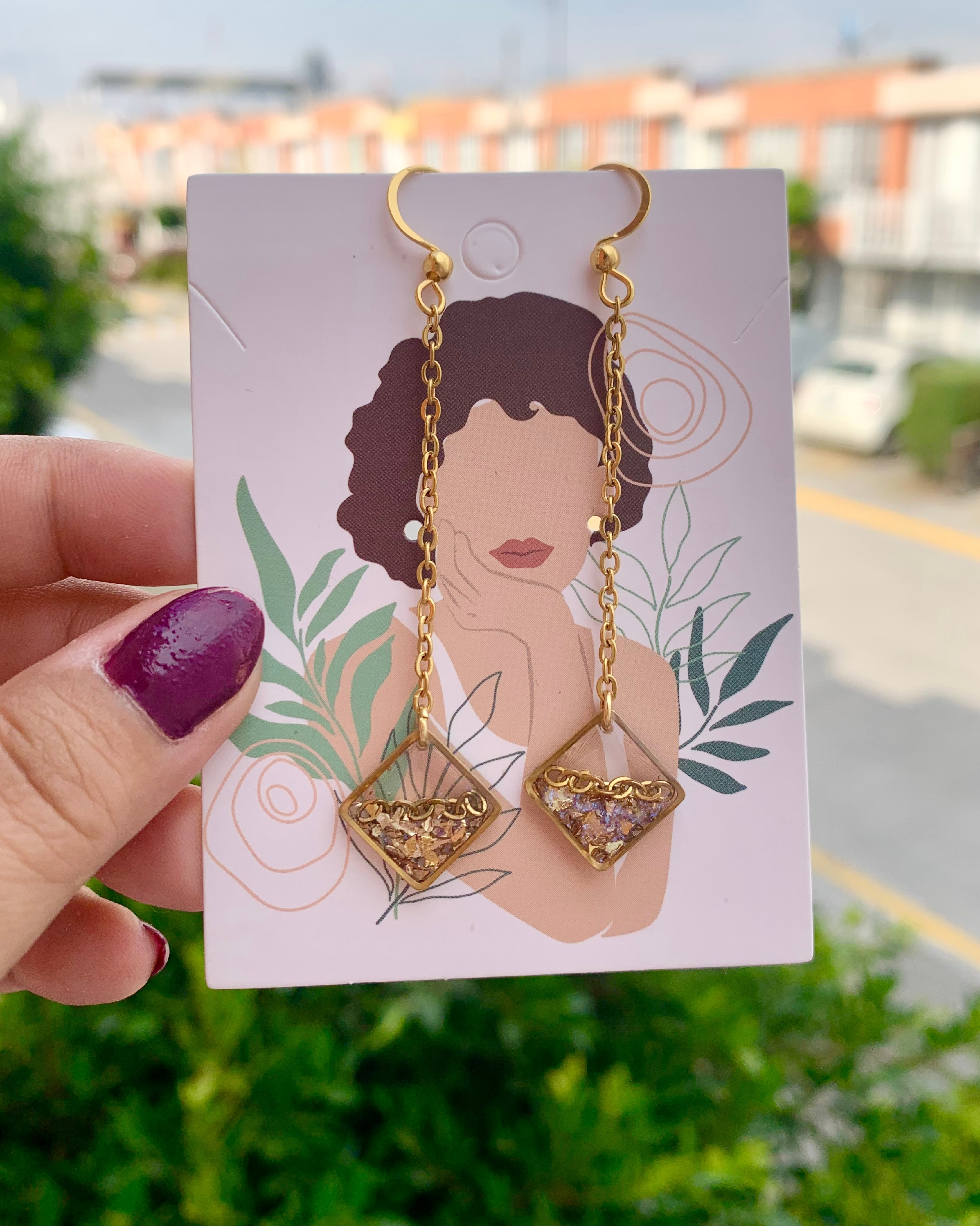 Aretes con piedras doradas, una elegante cadena de acero inoxidable y un diseño geométrico moderno