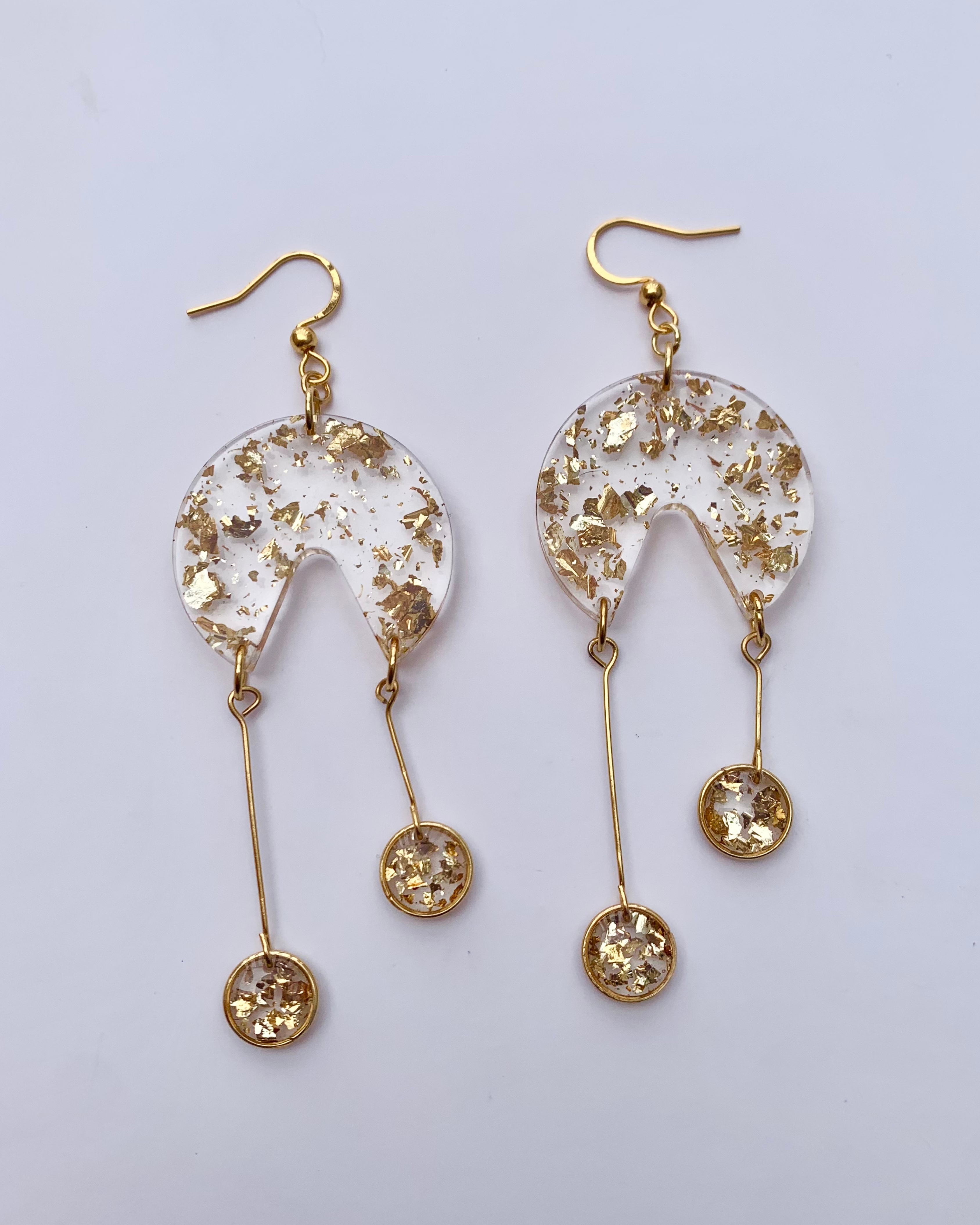 Pendientes de resina con pequeños círculos dorados colgando