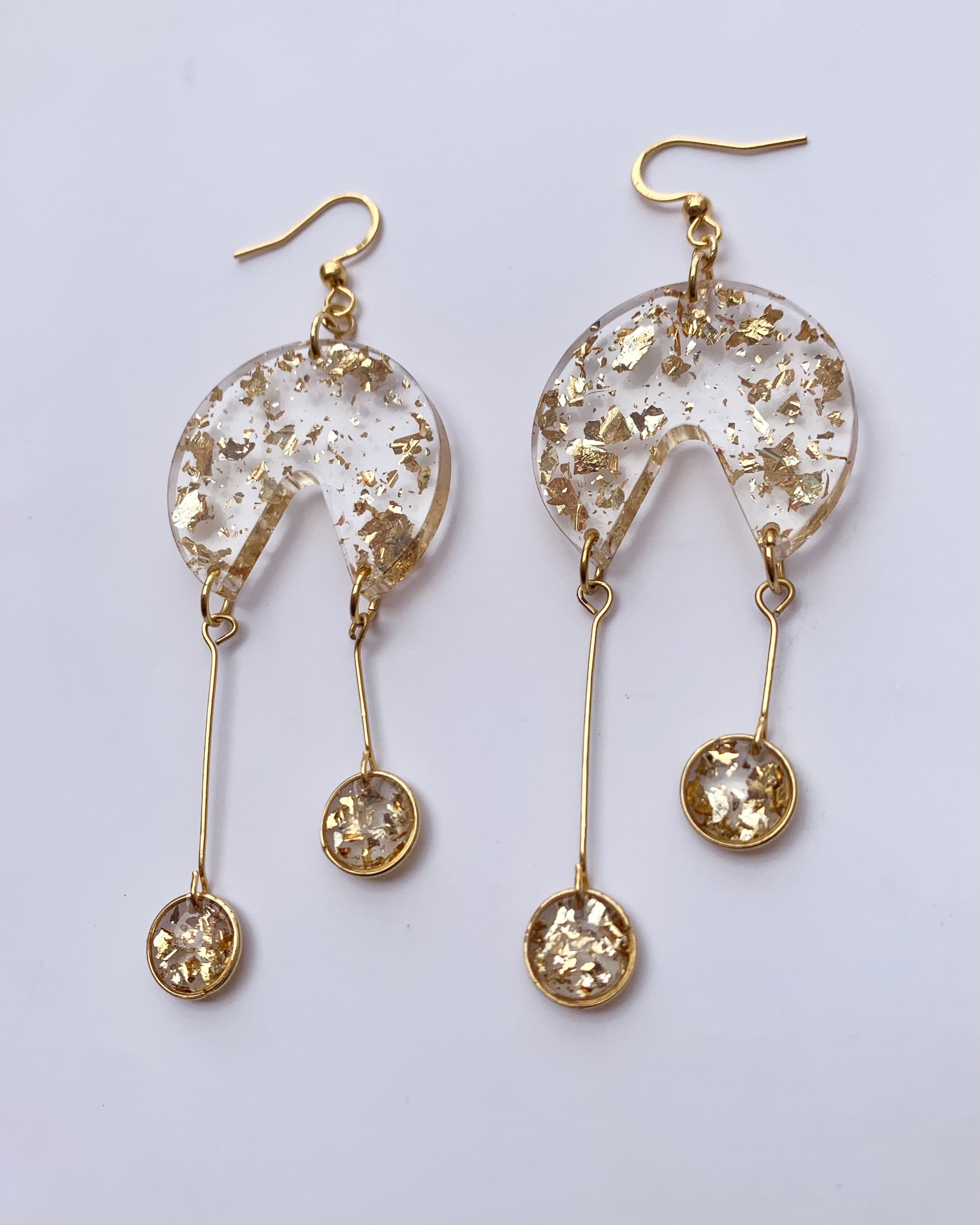 Pendientes de resina con pequeños círculos dorados colgando