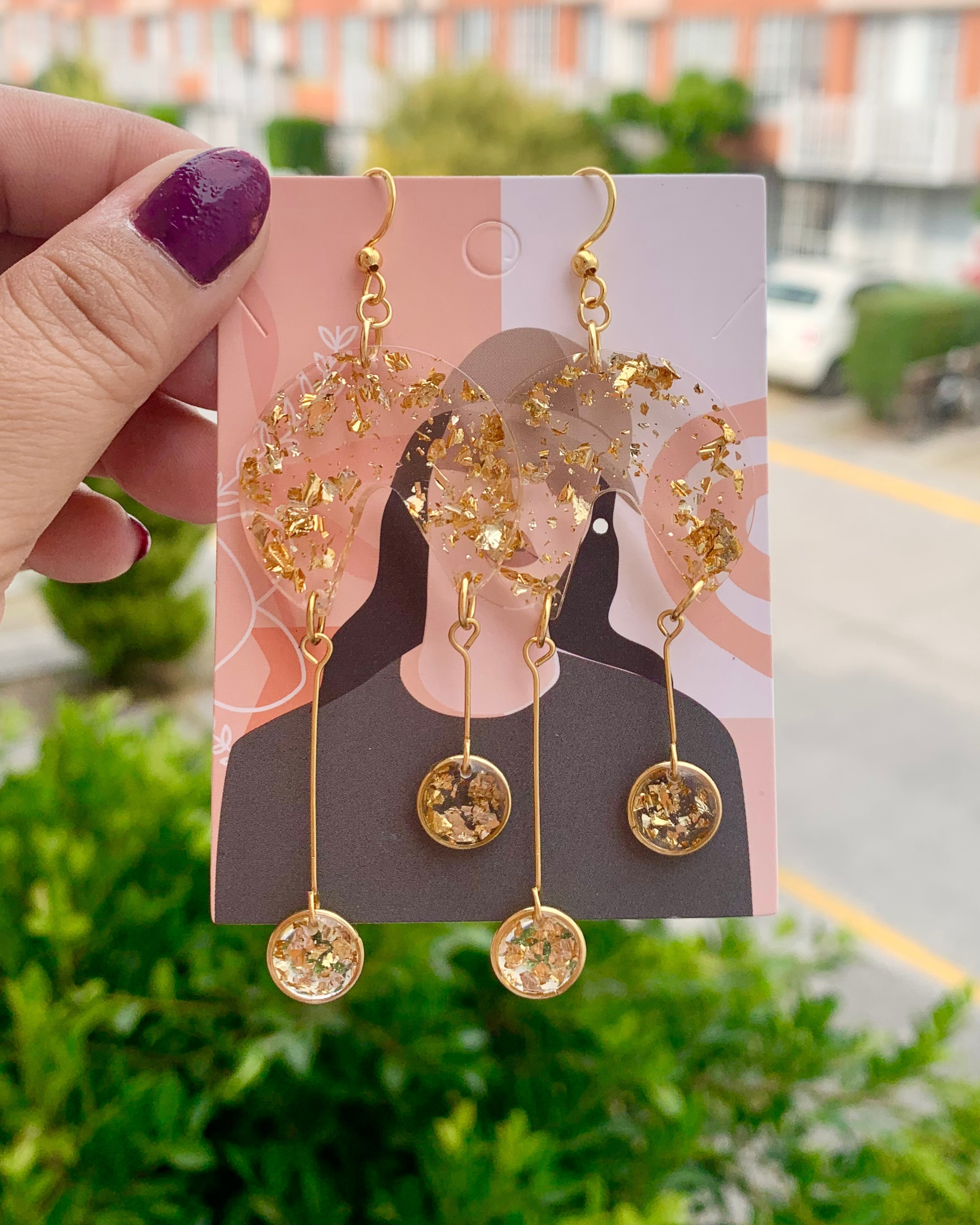 Pendientes de resina con pequeños círculos dorados colgando