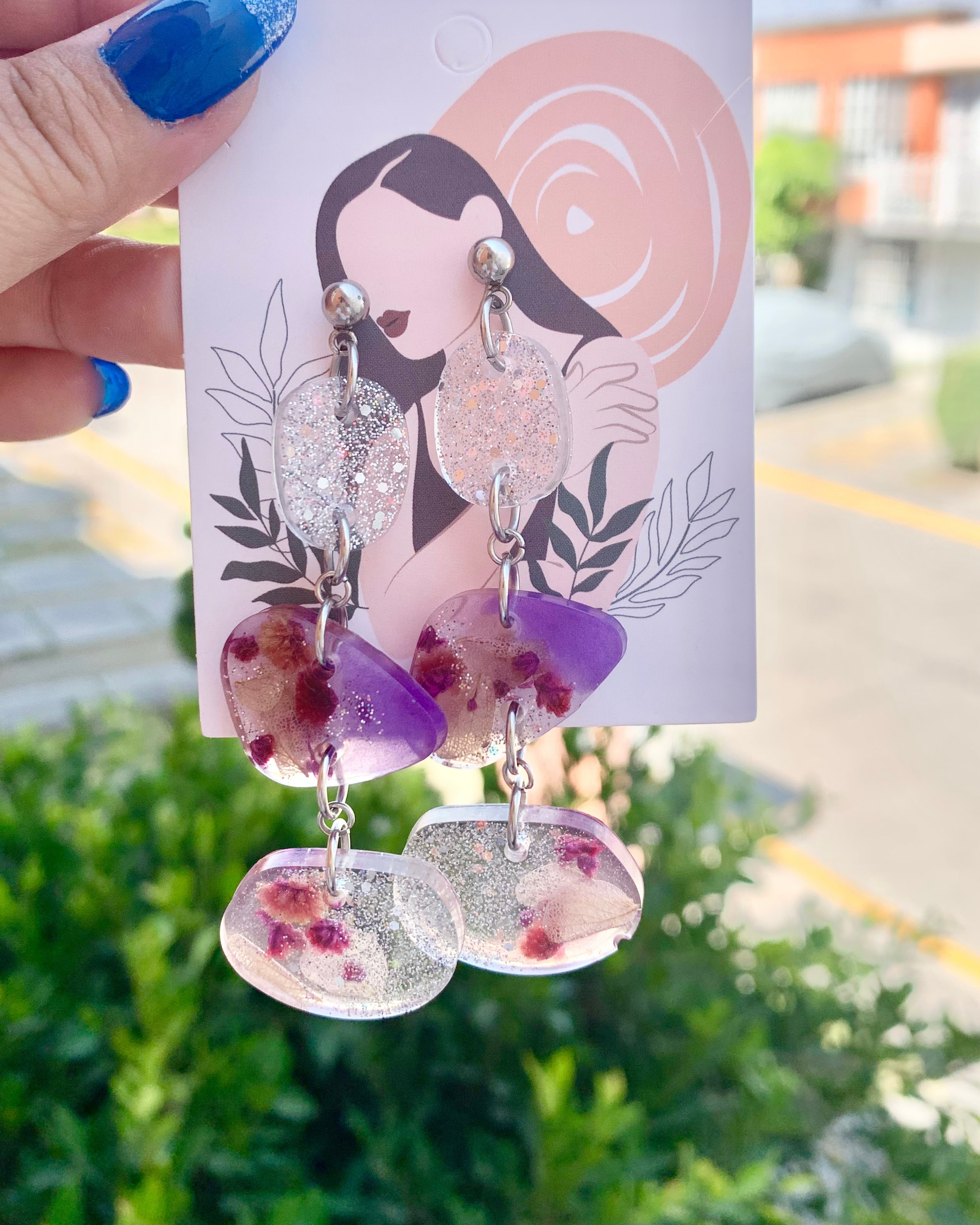 Pendientes de color morado y brillos plateados con flor