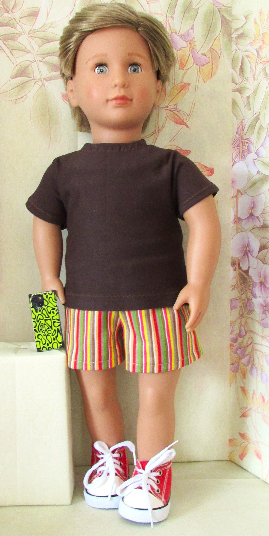 879   Brown tee-shirt, striped shorts, red trainers & new style mobile phone