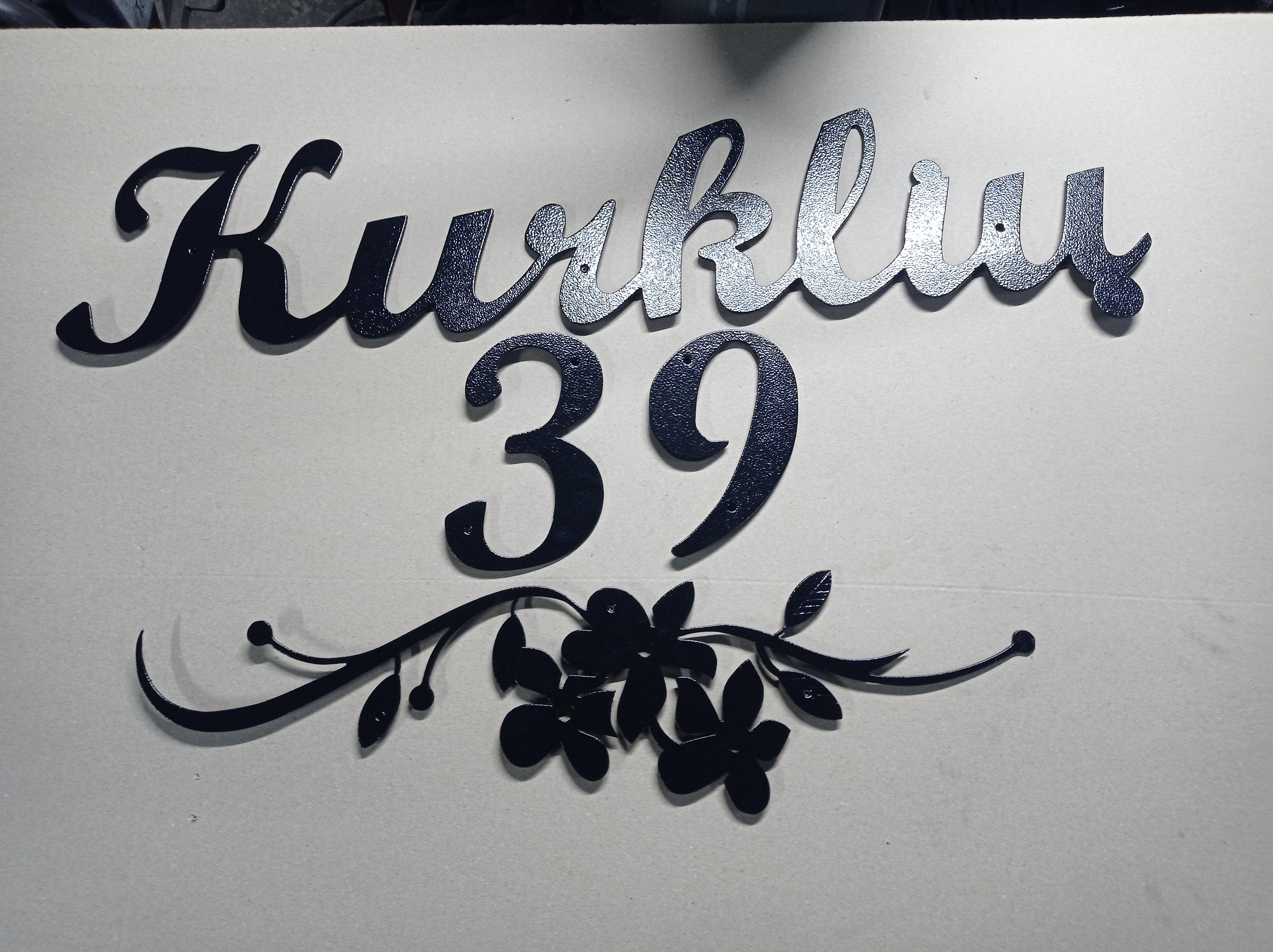 Gatvės užrašas su gėlės dekoracija