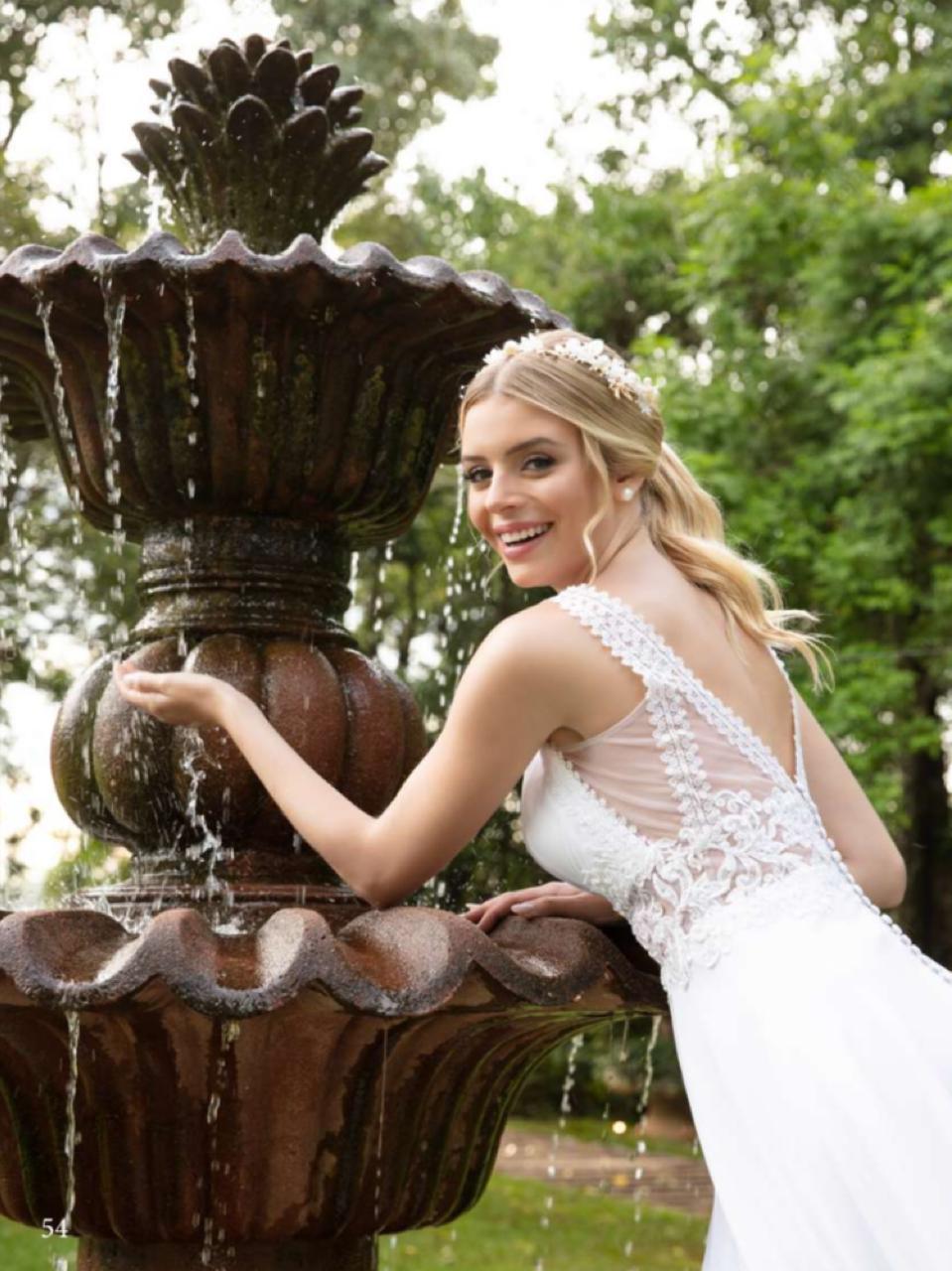 Vestido noiva fluído em musseline branco natural, apresenta ampla saia godê finalizada com barrado aplicado em renda fio de seda.