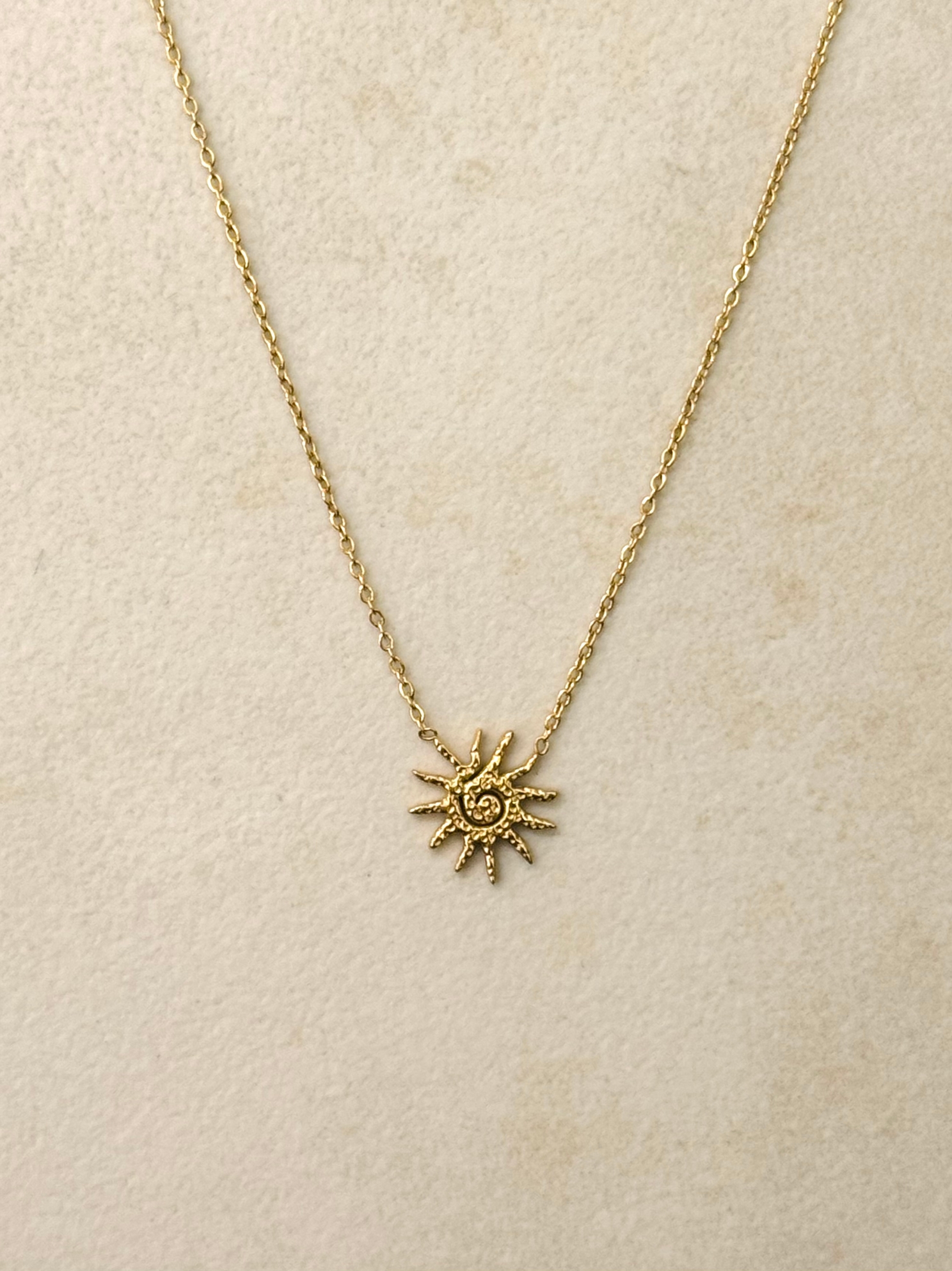 Le collier plaqué or en acier inoxydable et son pendentif soleil