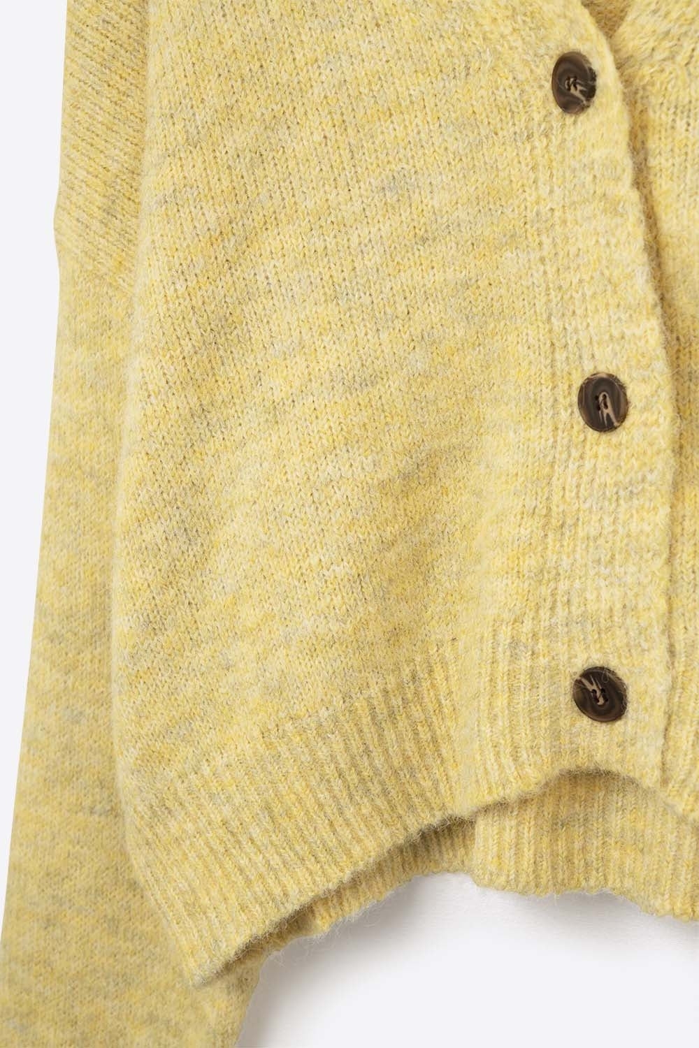 Le cardigan jaune et ses boutons marron