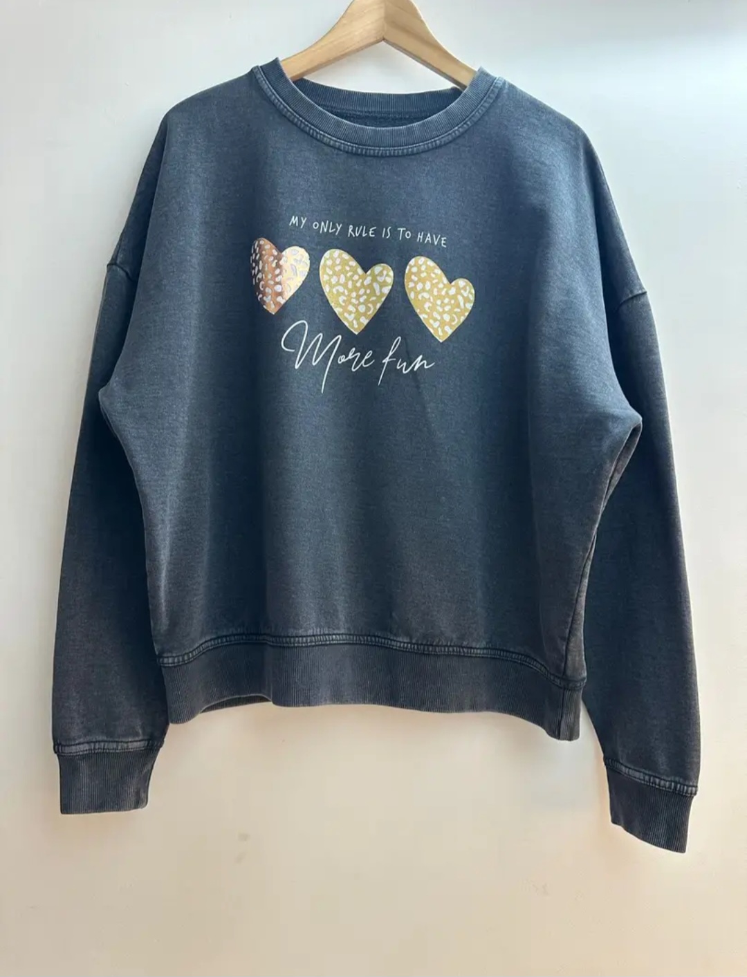 Le sweat-shirt gris à motifs cœurs