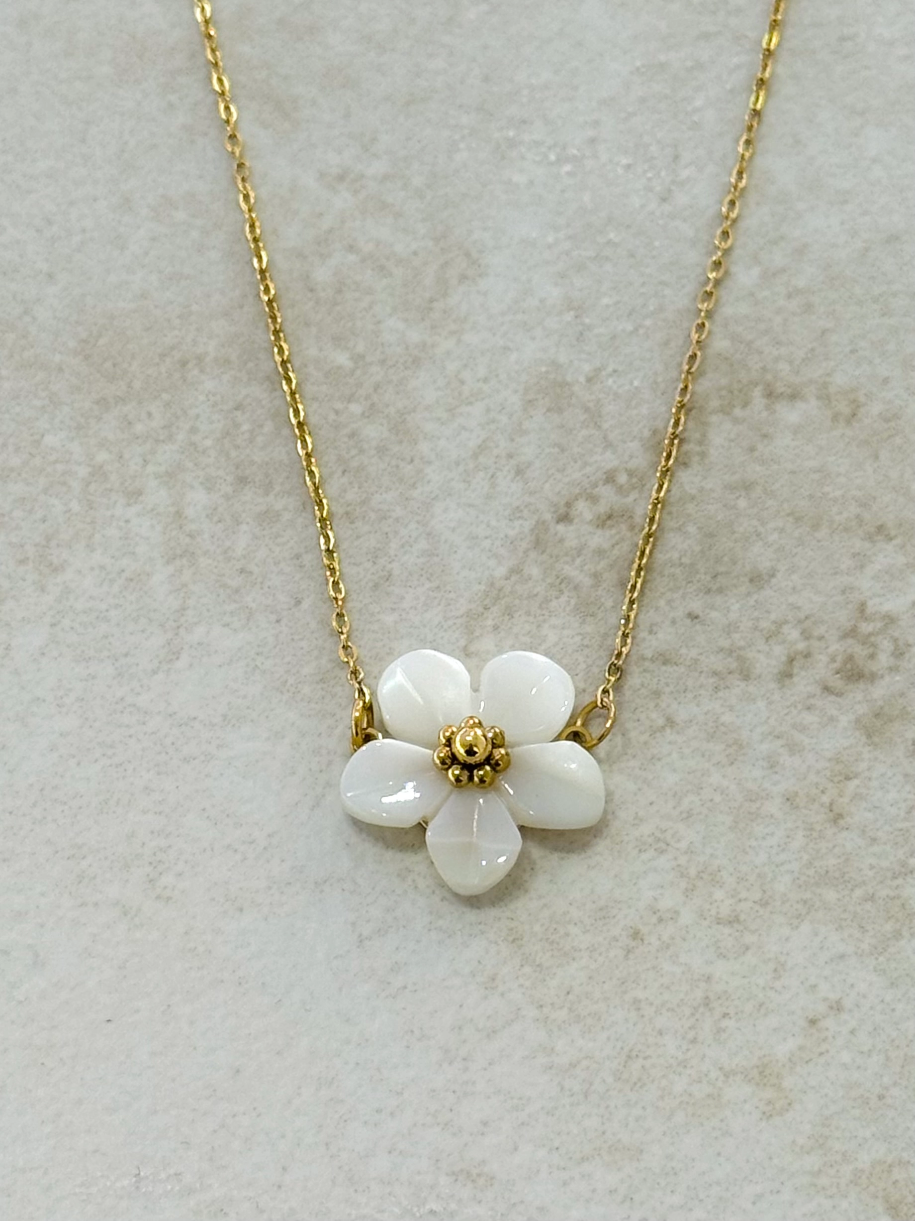 Le collier plaqué or, et sa fleur acrylique blanche
