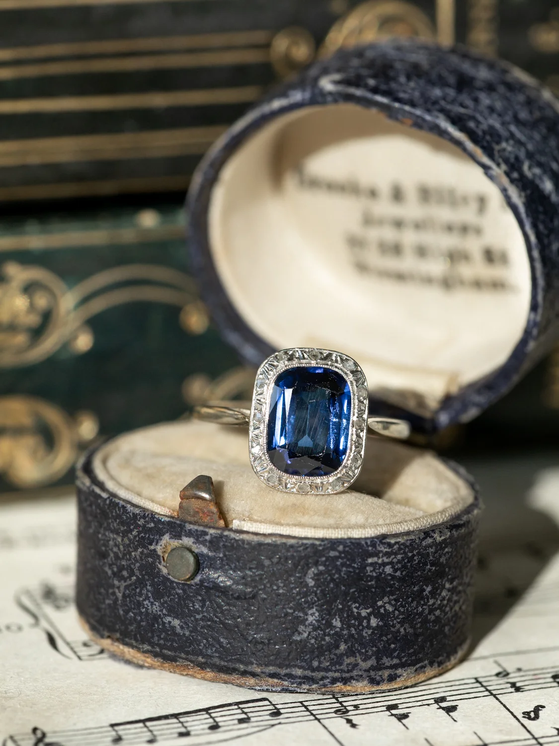 LA BESSIE, adorable bague Art Déco (circa 1920) en platine & or gris 14 carats, saphir Verneuil taille coussin et petits diamants