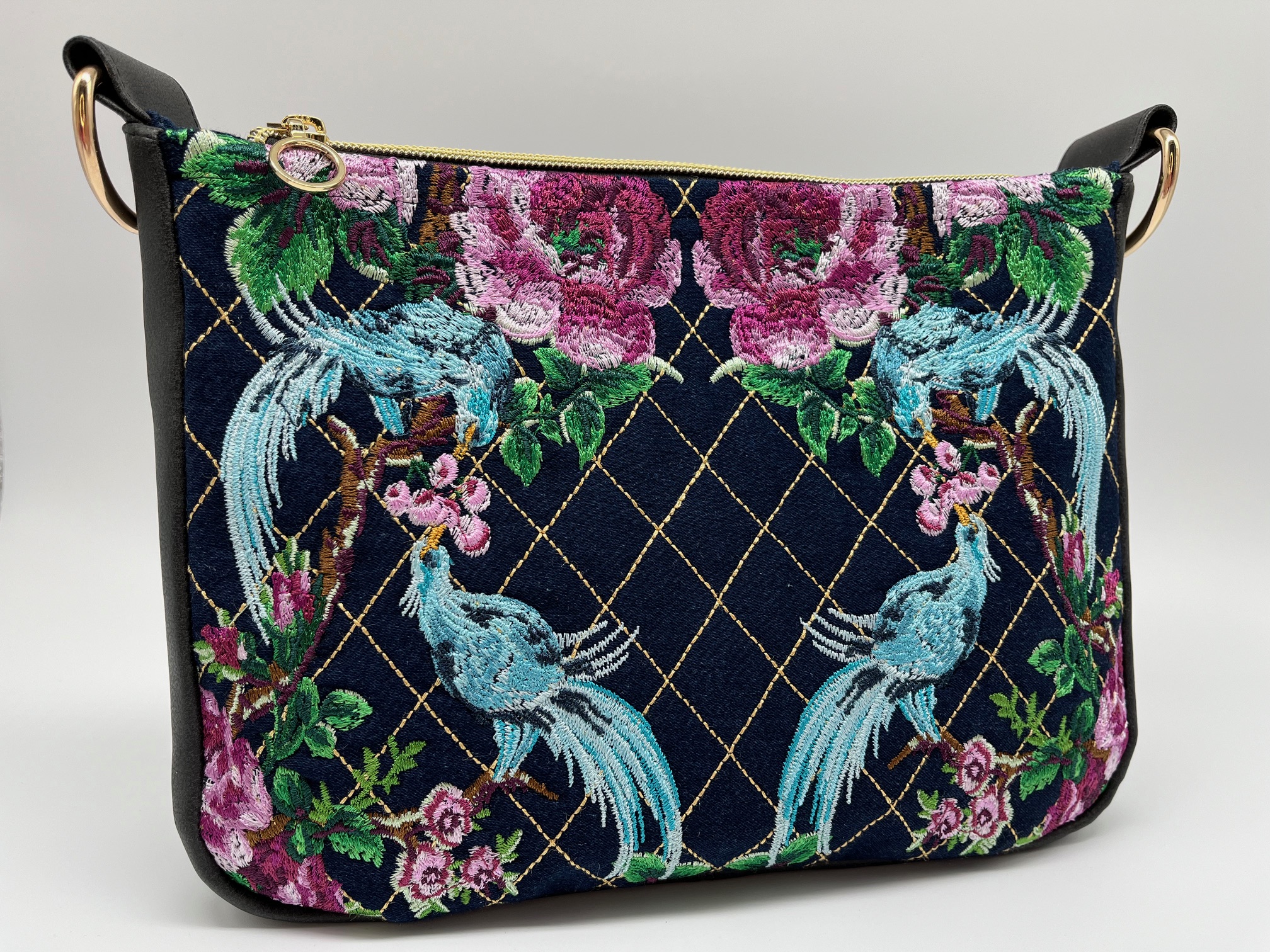 Crossbody schoudertas van zwart kunstleer met voorpaneel van denim met borduursel.