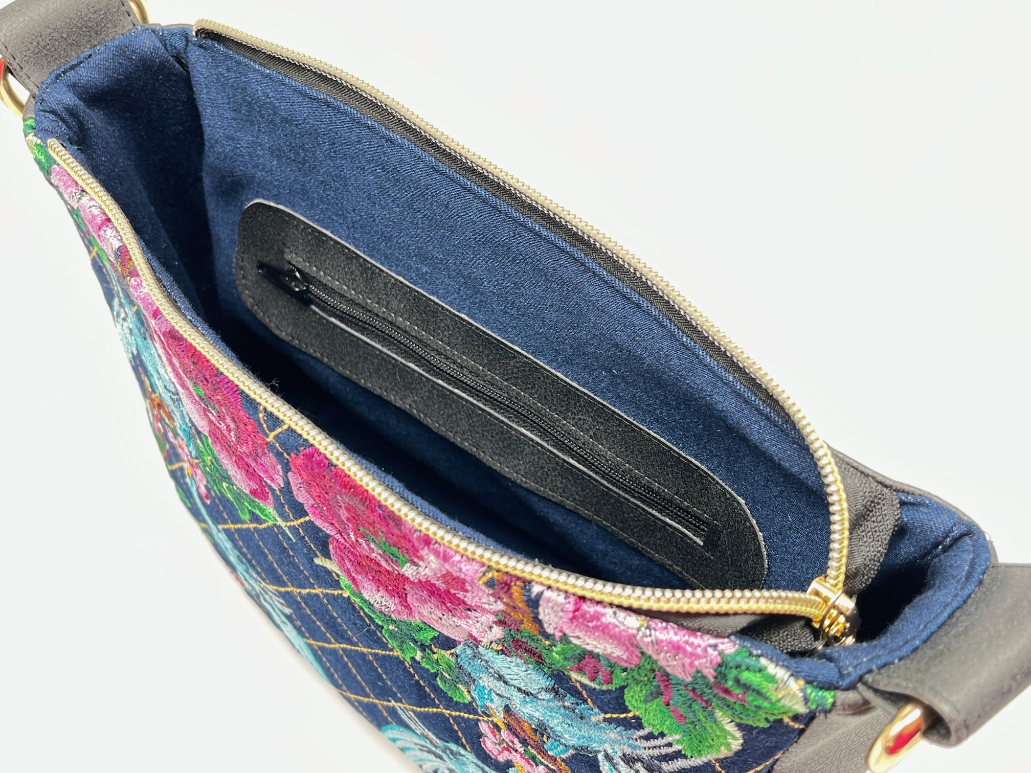 Crossbody schoudertas van zwart kunstleer met voorpaneel van denim met borduursel.