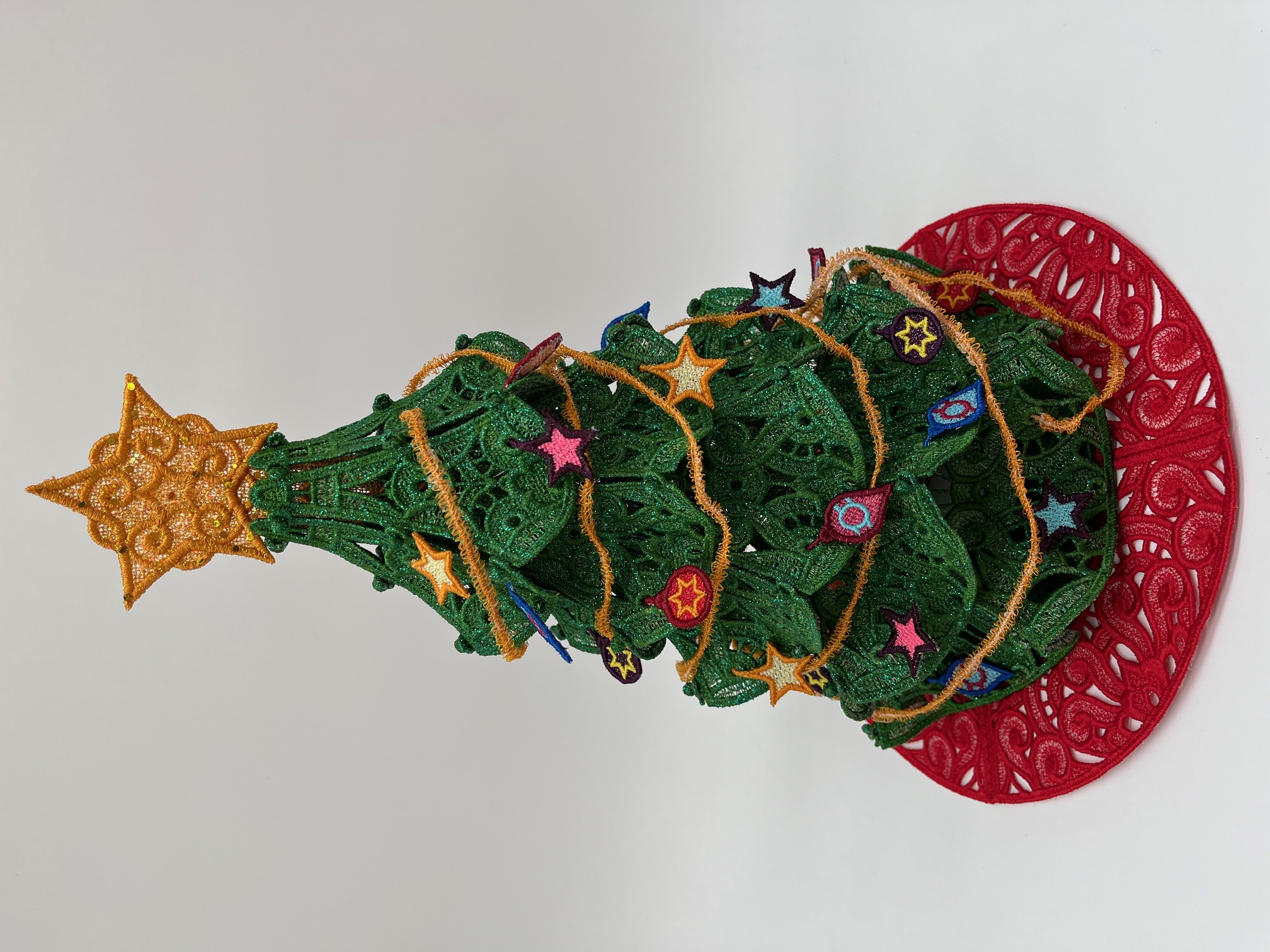 Geborduurde kerstboom met kleine ornamentjes en kerstslinger