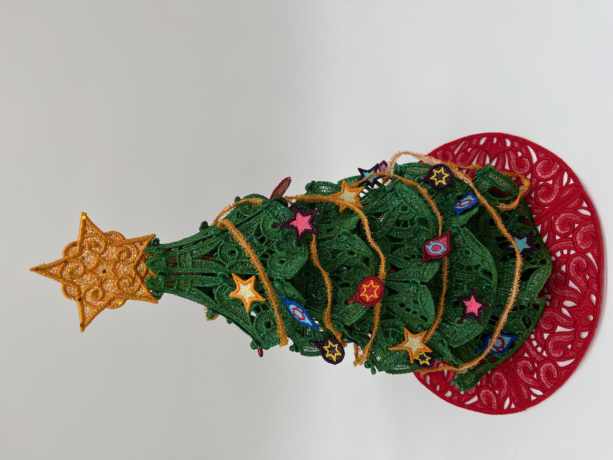 Geborduurde kerstboom met kleine ornamentjes en kerstslinger