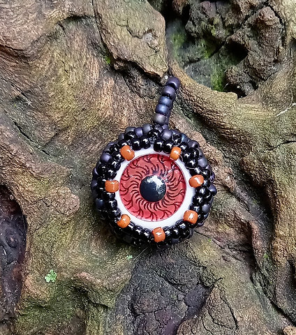 Brown eye black iridescent beaded pendant