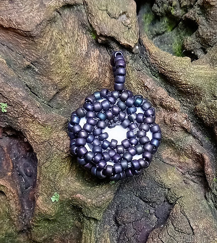 Brown eye black iridescent beaded pendant