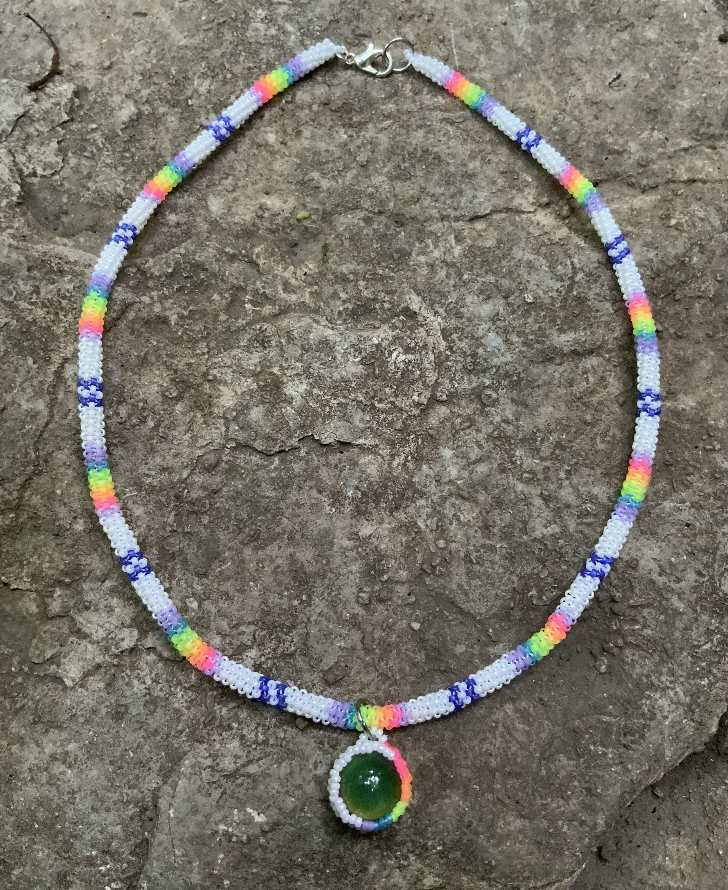 Blacklight reactive rainbows in the clouds gourd stitched necklace 