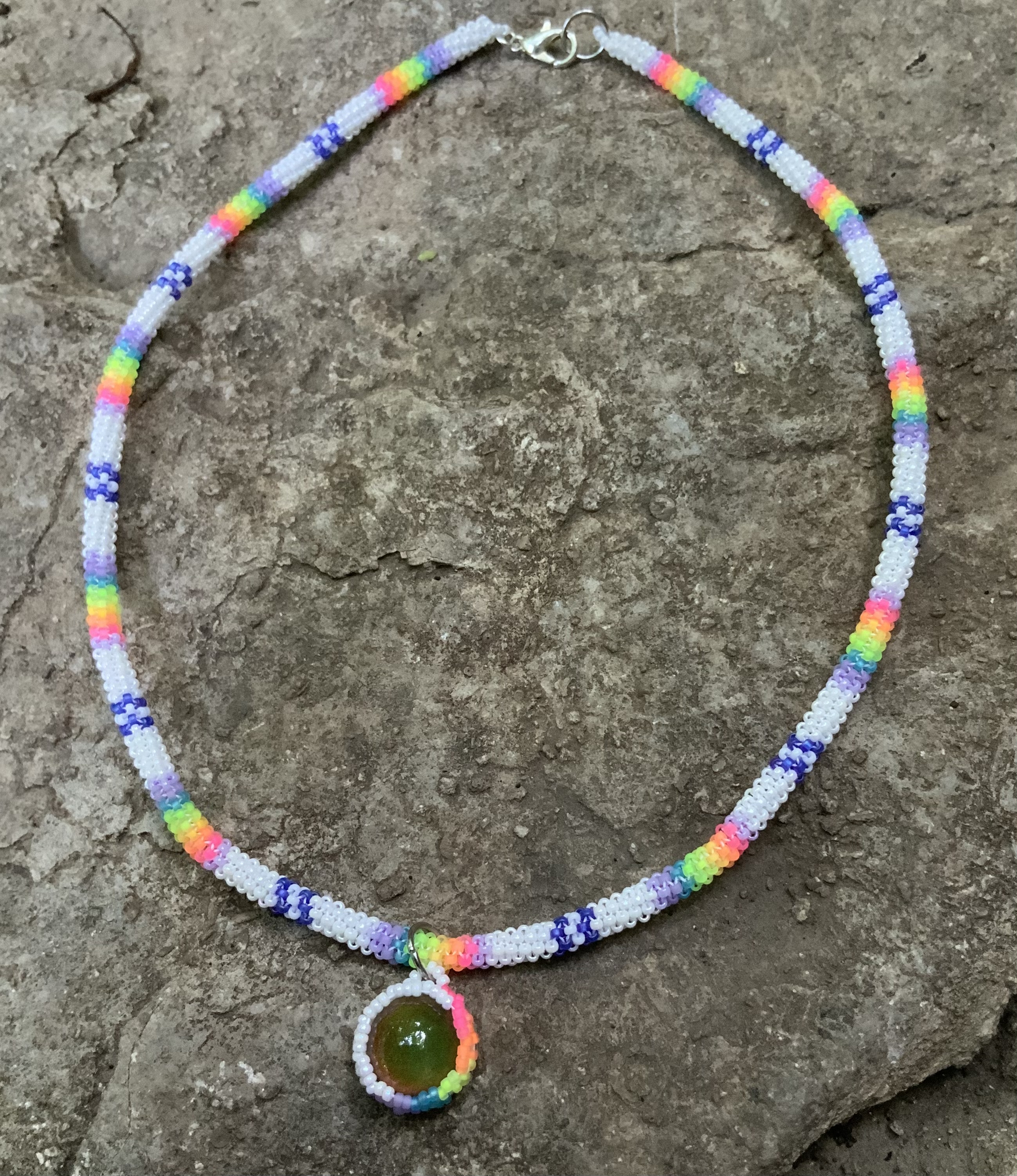 Blacklight reactive rainbows in the clouds gourd stitched necklace 
