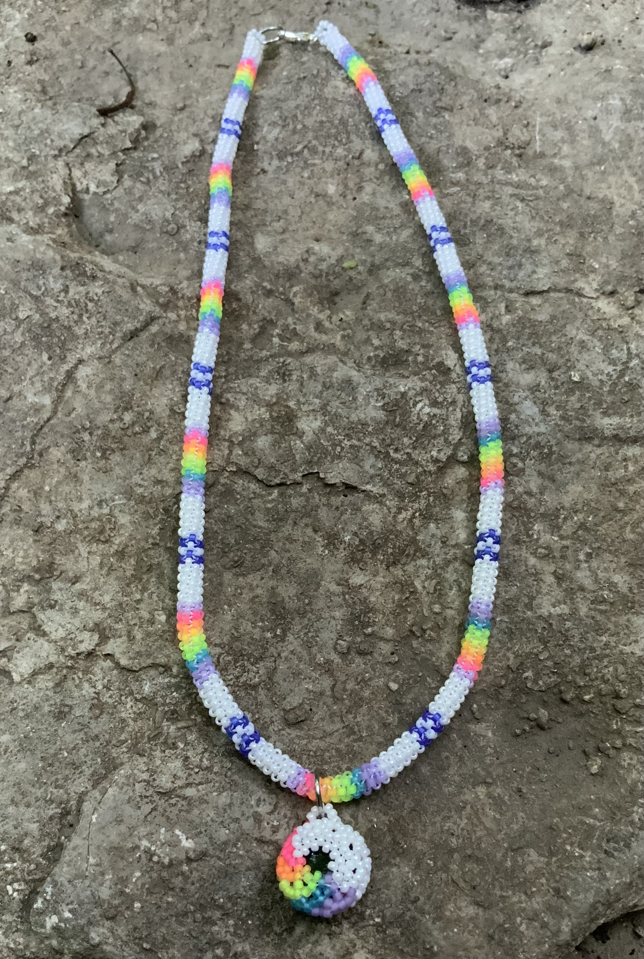 Blacklight reactive rainbows in the clouds gourd stitched necklace 