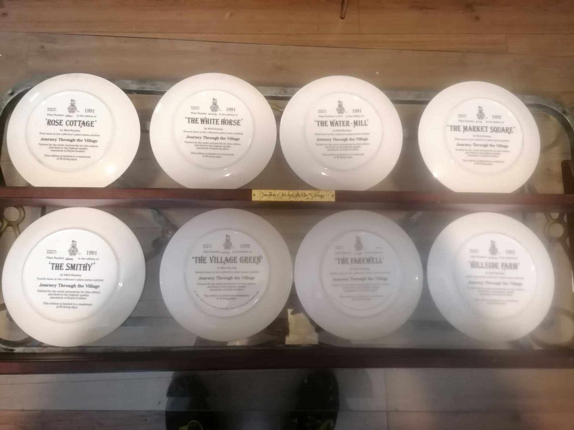 Set of 8 1990s royal doulton plates journey thru the village with genuine plate rack