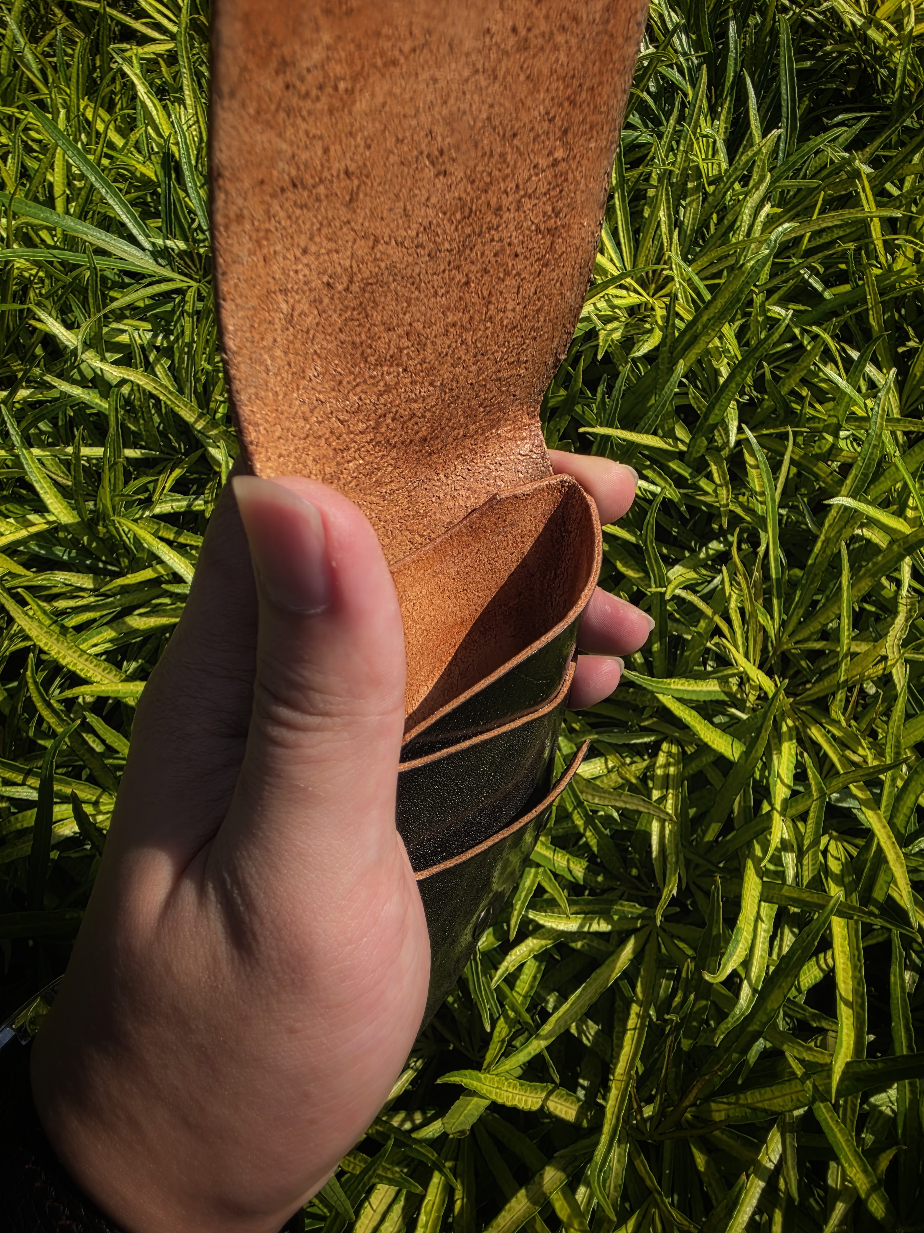 The Fuji: A vertical leather card and cash wallet in saddle black accented with a bit of blue