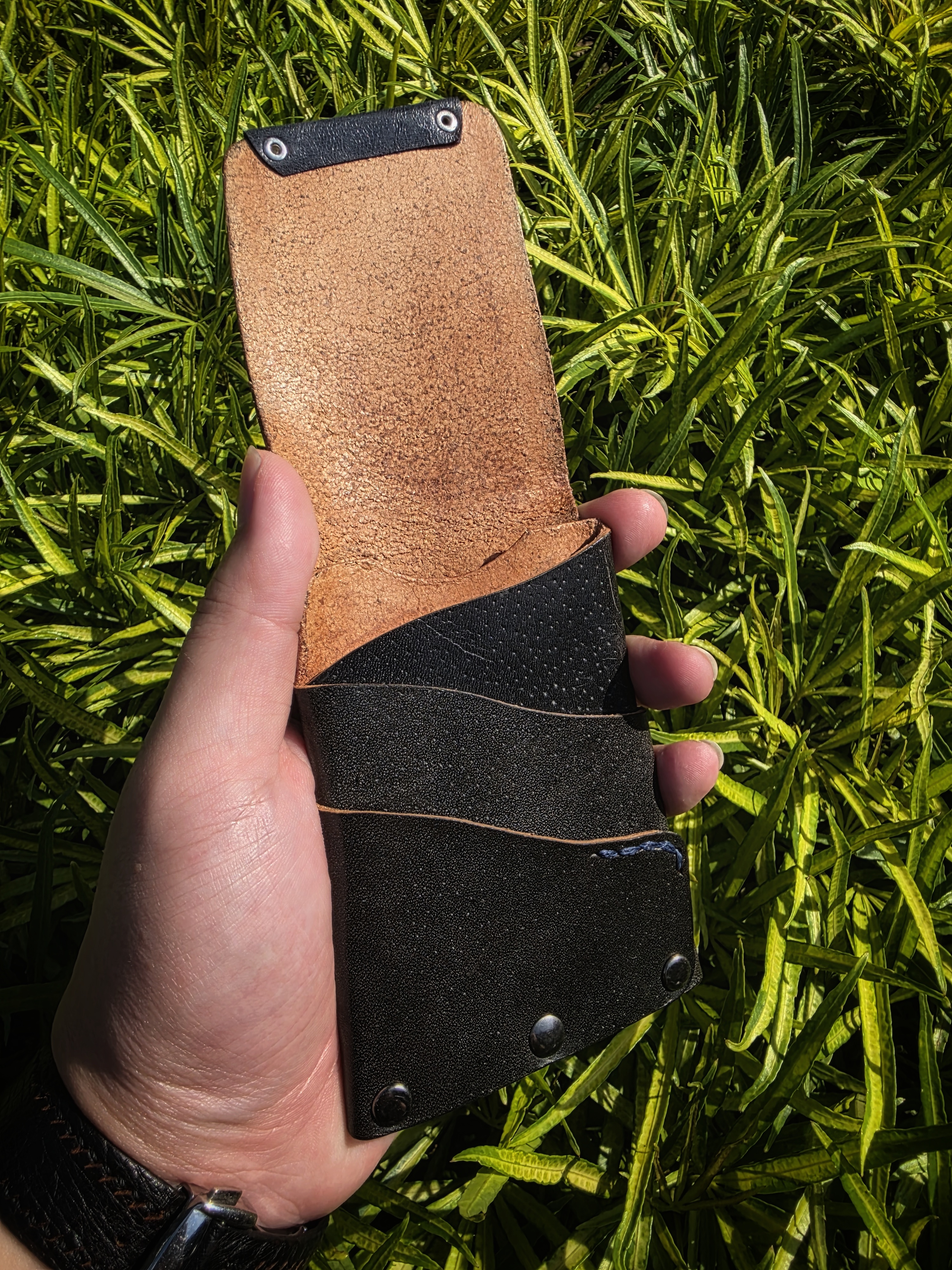 The Fuji: A vertical leather card and cash wallet in saddle black accented with a bit of blue