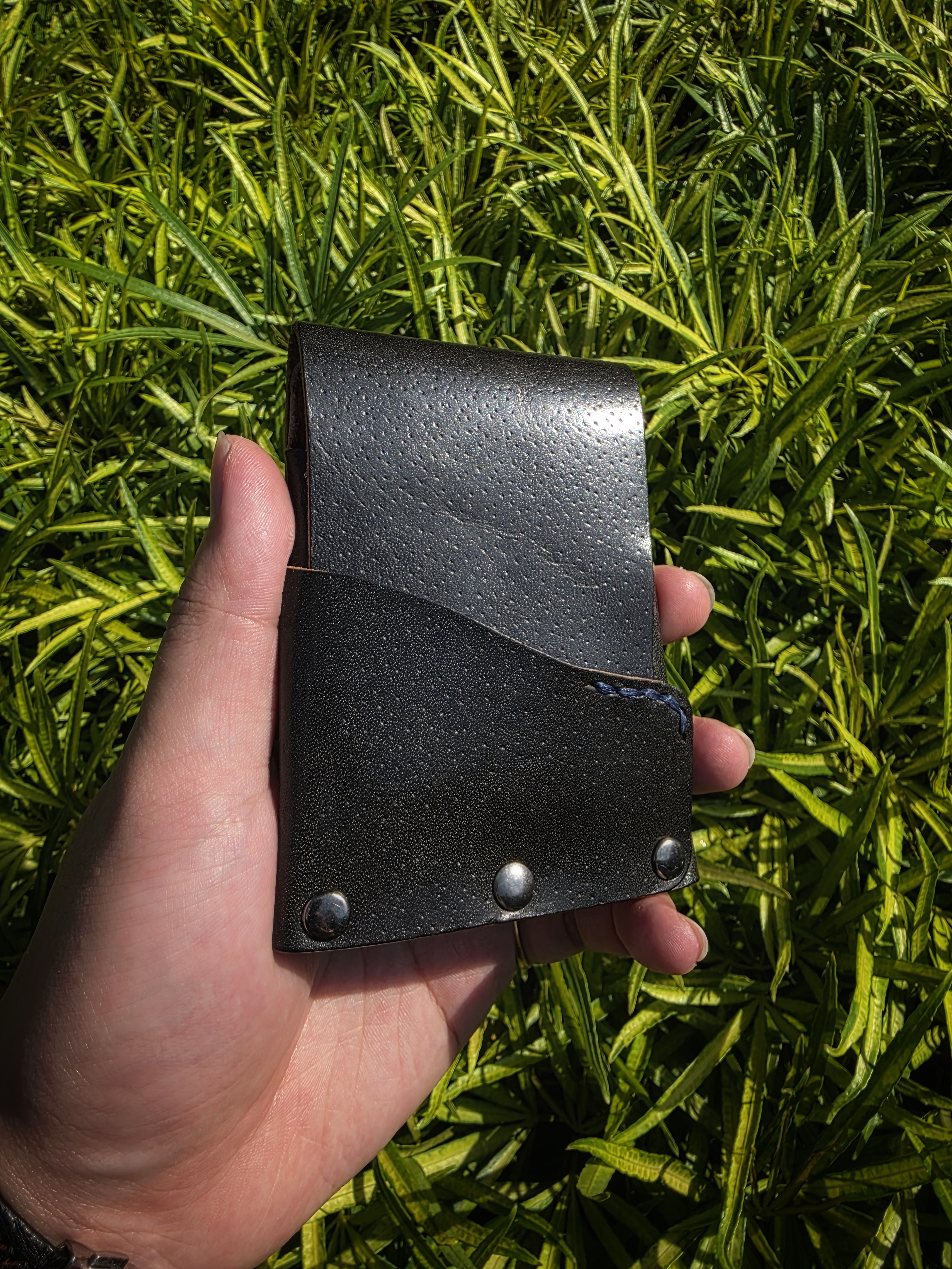 The Fuji: A vertical leather card and cash wallet in saddle black accented with a bit of blue
