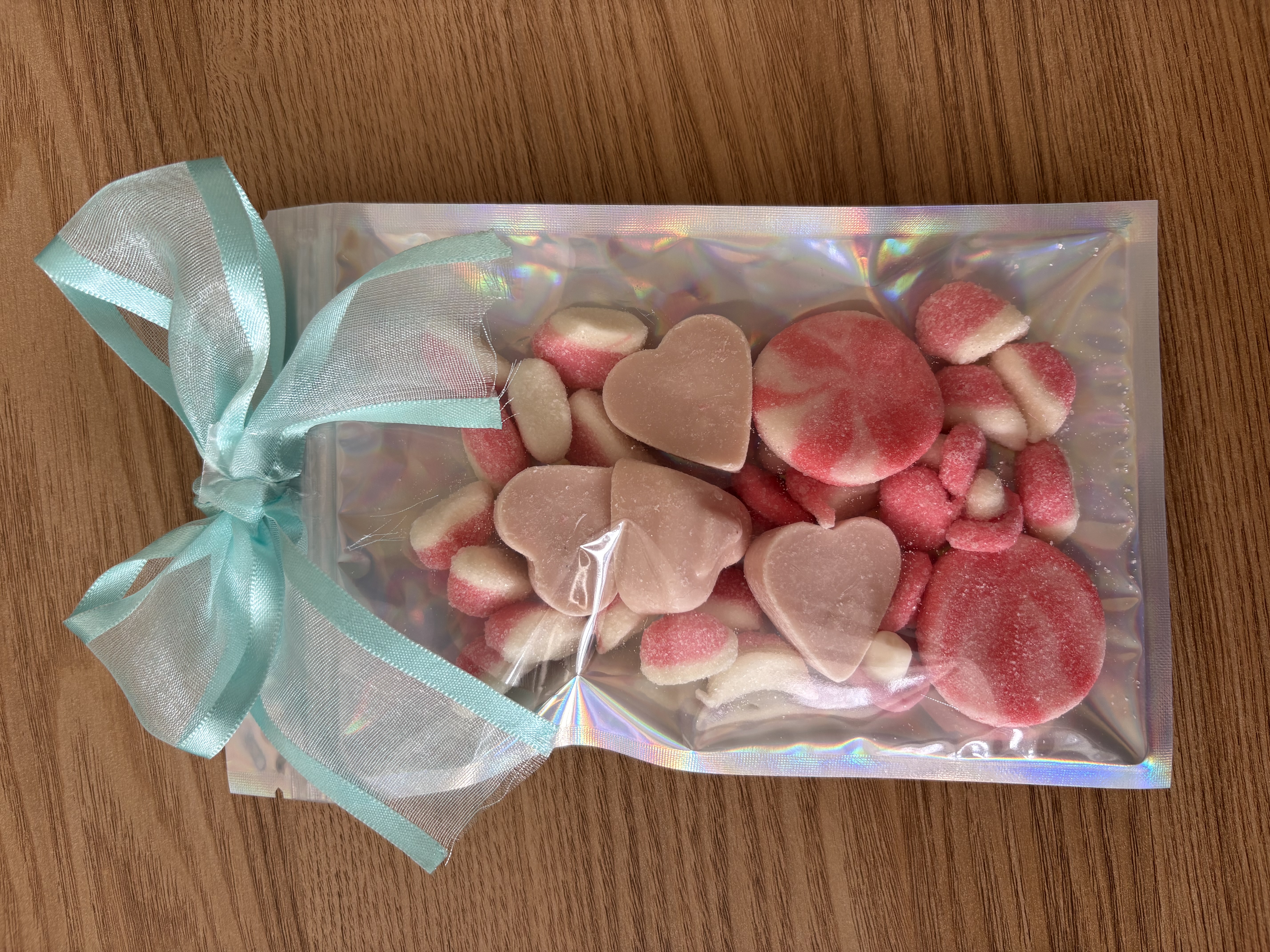Large holographic sweet pouch eith a variety of sweets and a beautiful ribbon to the top.