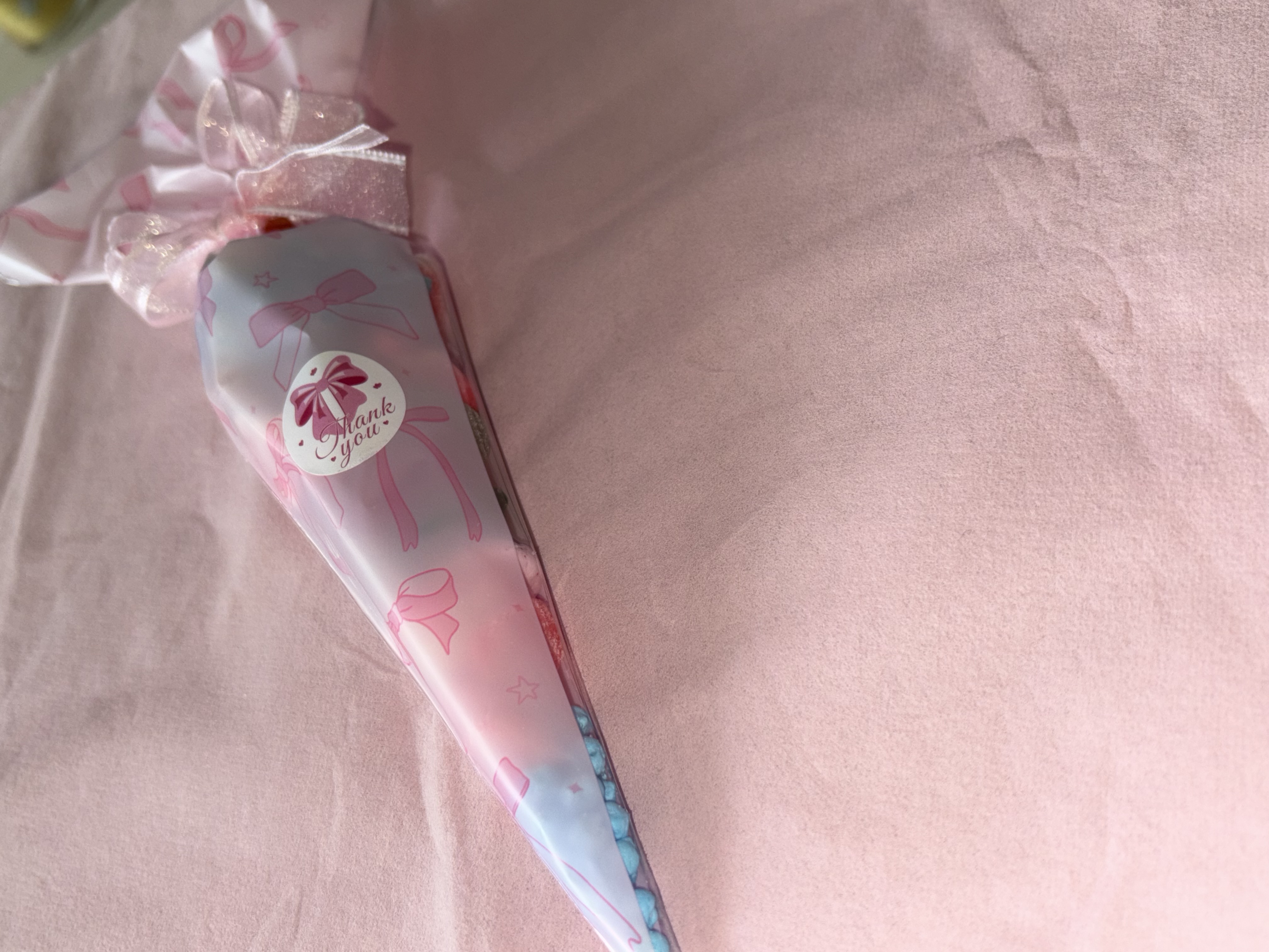 Beautiful pink bow design complete with a variety of sweets and two tone organza ribbon