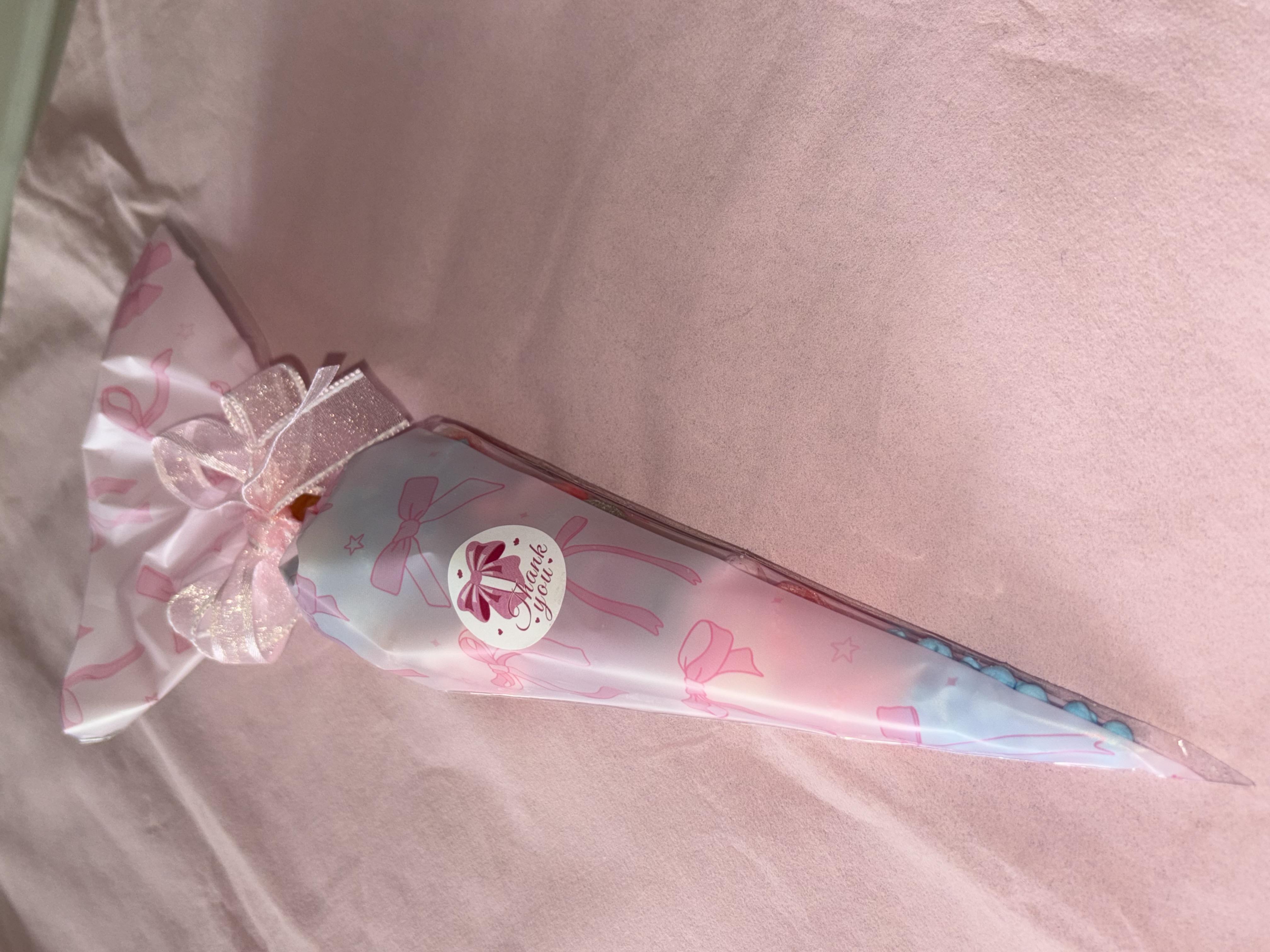 Beautiful pink bow design complete with a variety of sweets and two tone organza ribbon