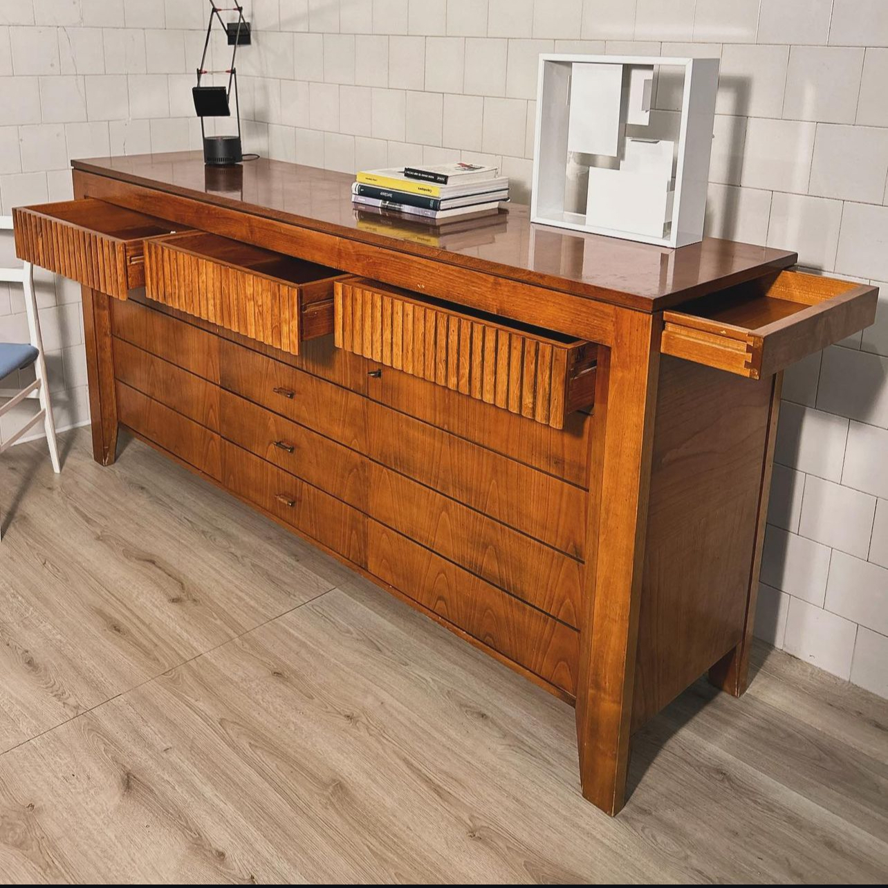 Sideboard in cherry wood and finely crafted ribbing features an upper part with ribbing on the 3 top quality front drawers, 2 doors with lock and two internal adjustable shelves, 7 front drawers, 2 side drawers. Morelato, Italy