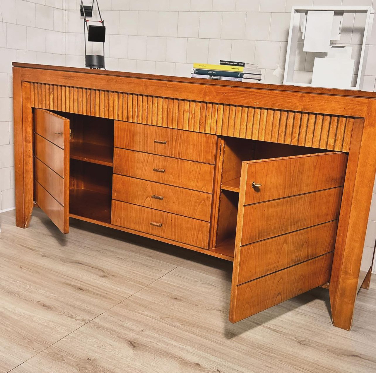 Sideboard in cherry wood and finely crafted ribbing features an upper part with ribbing on the 3 top quality front drawers, 2 doors with lock and two internal adjustable shelves, 7 front drawers, 2 side drawers. Morelato, Italy