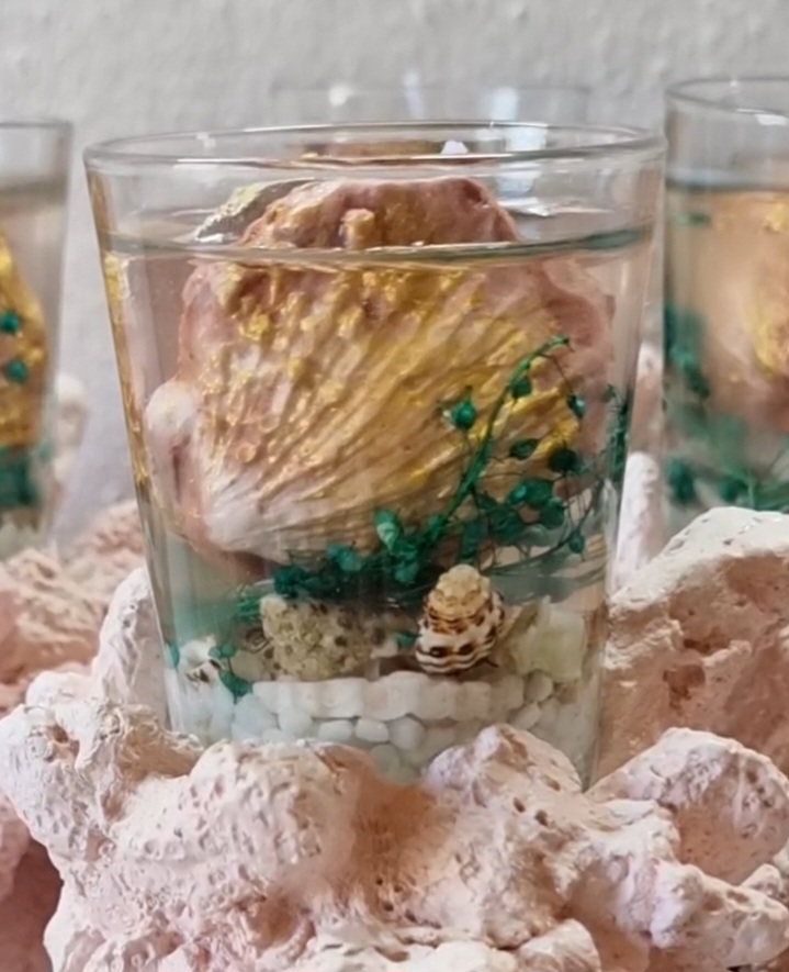Transparent candle in a glass on top of a coral