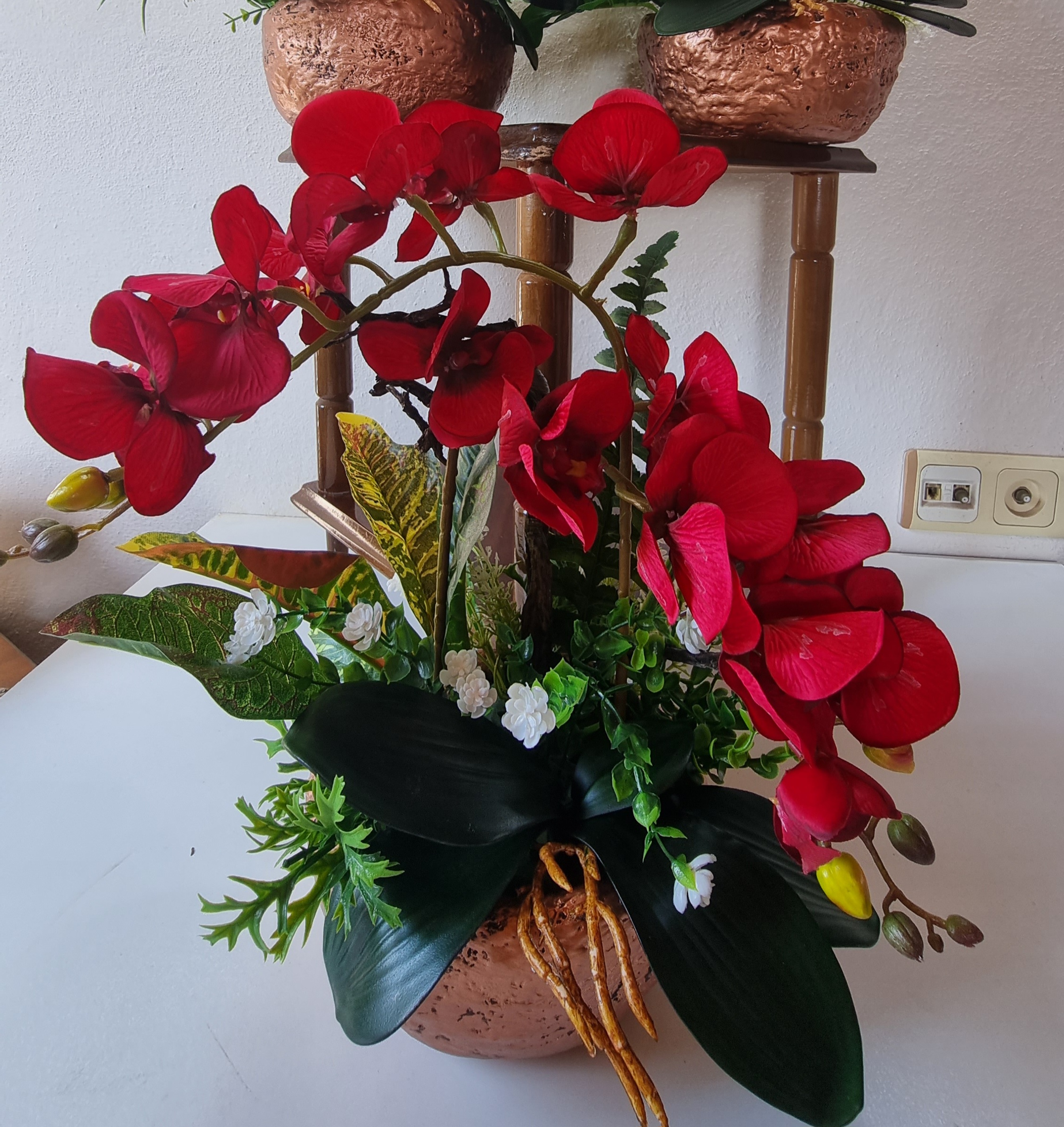 Planter with artificial red orchids