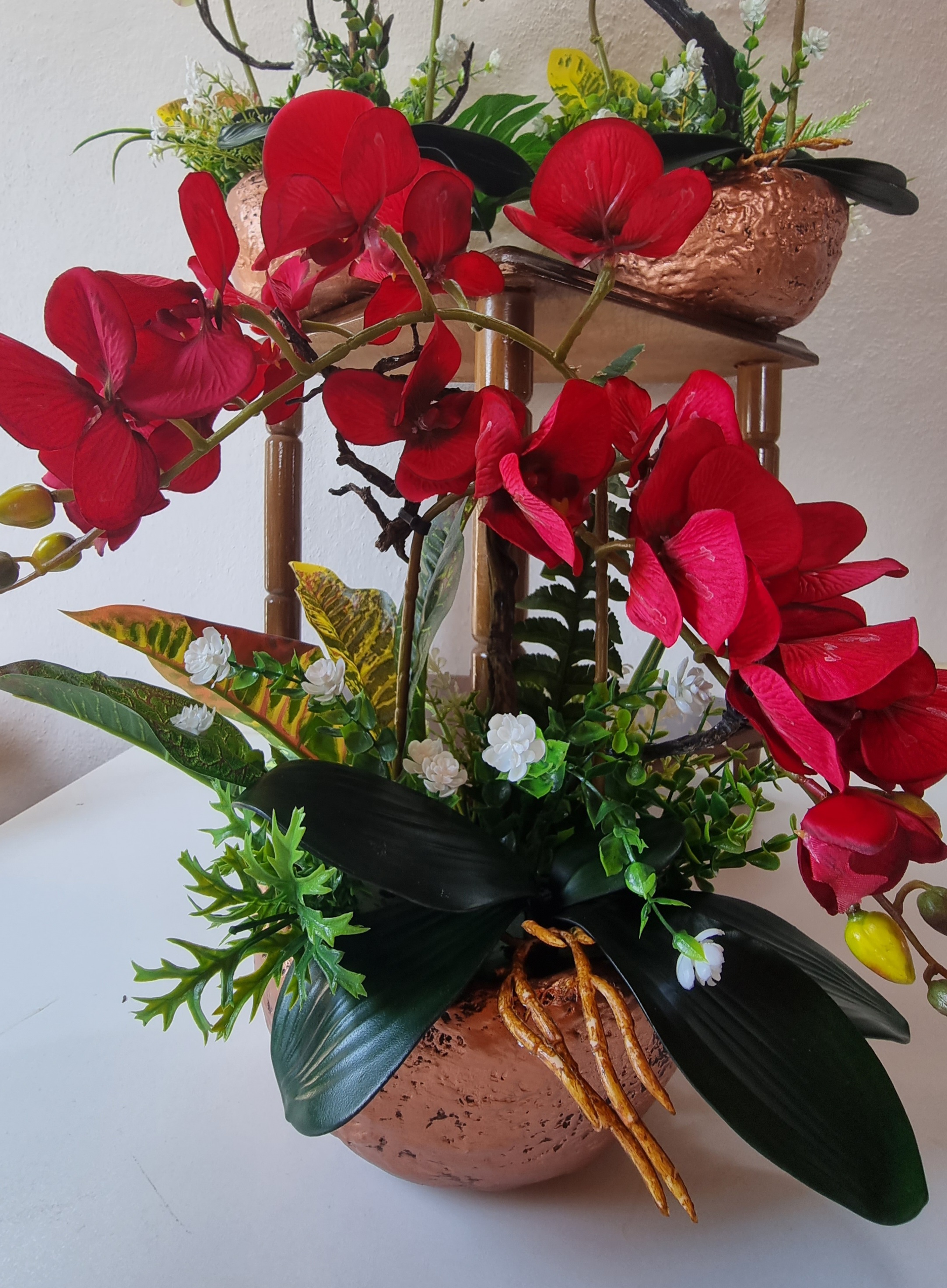 Planter with artificial red orchids 