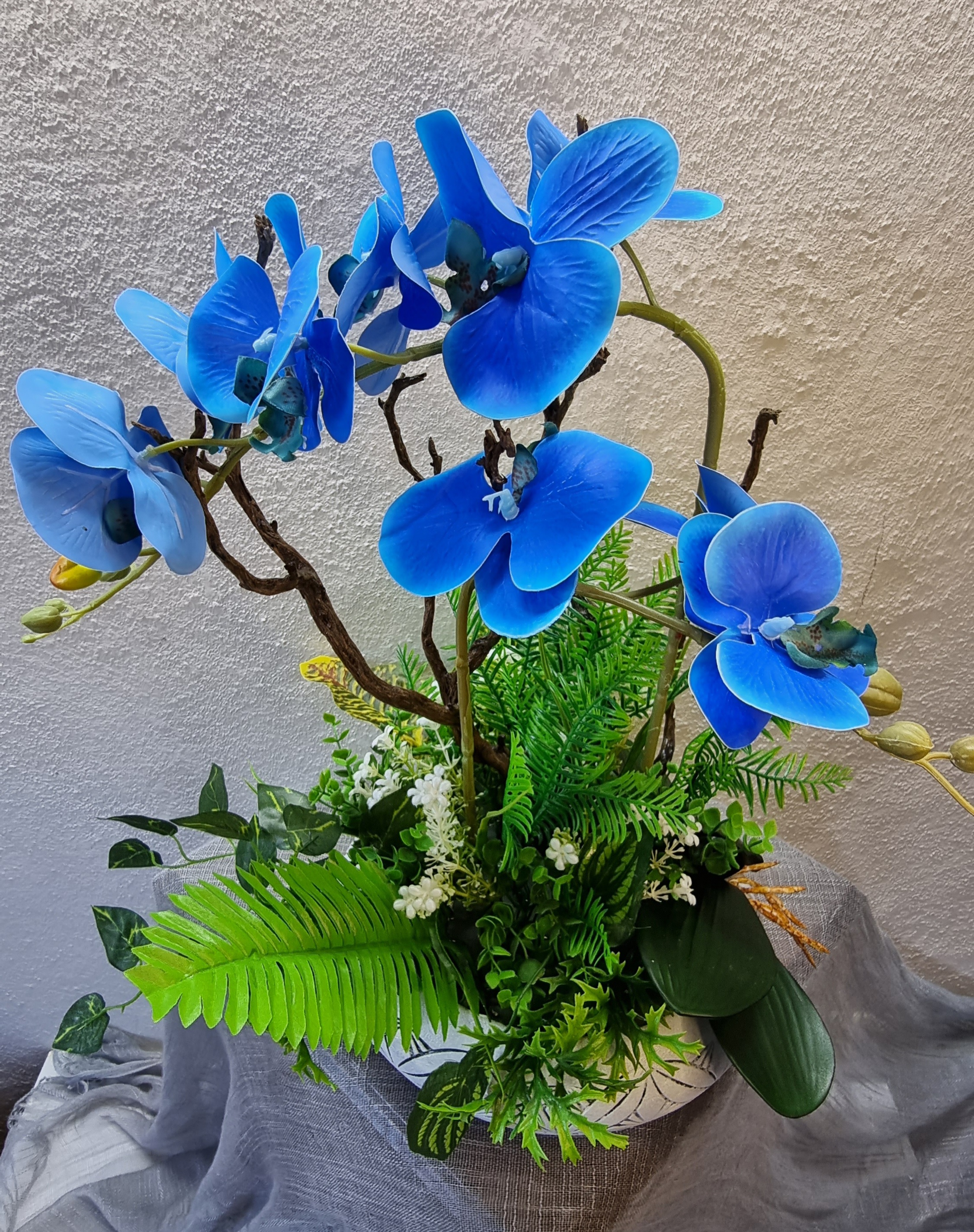 Normal-size white planter with artificial blue orchids