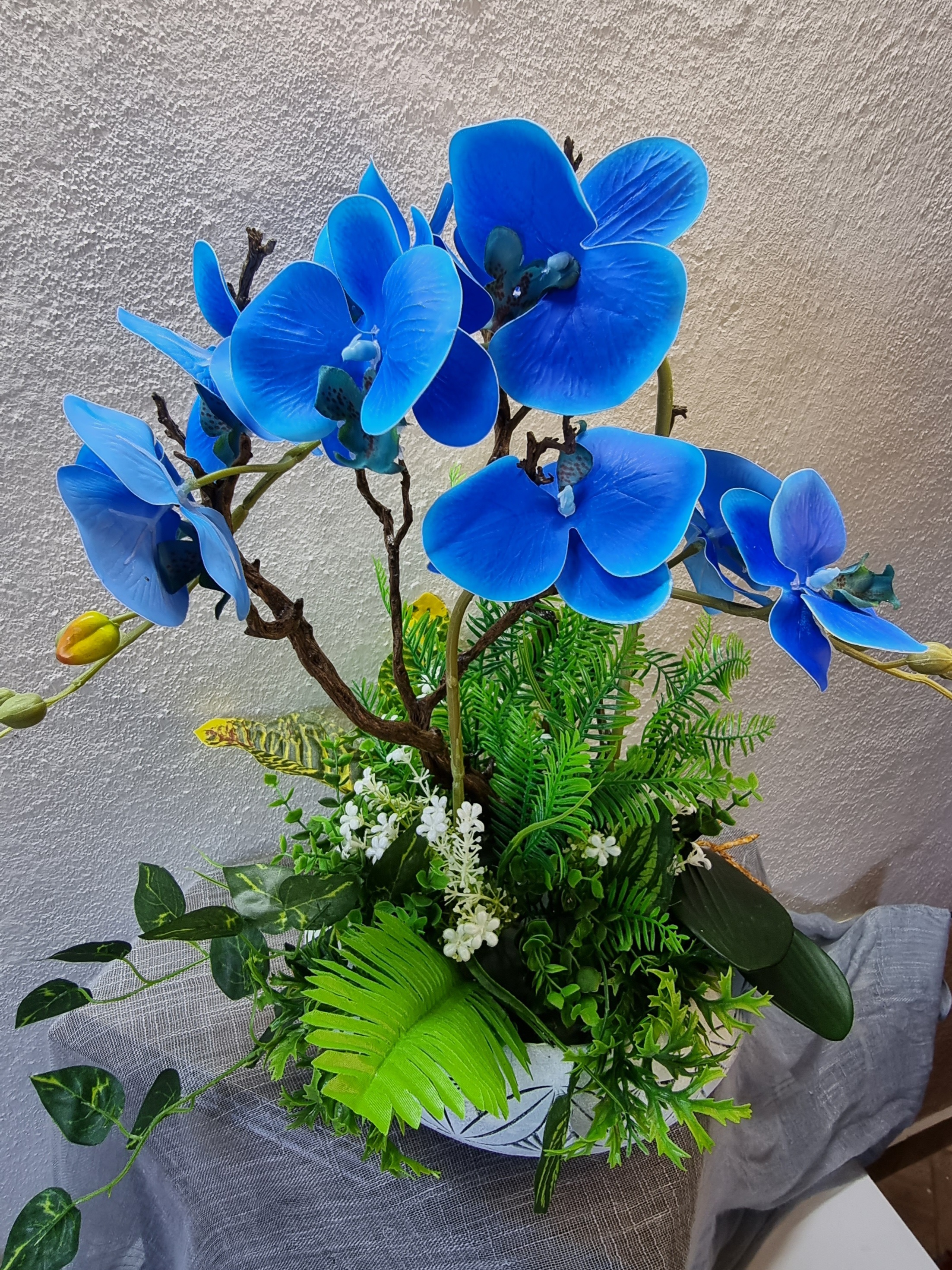 Normal-size white planter with artificial blue orchids 