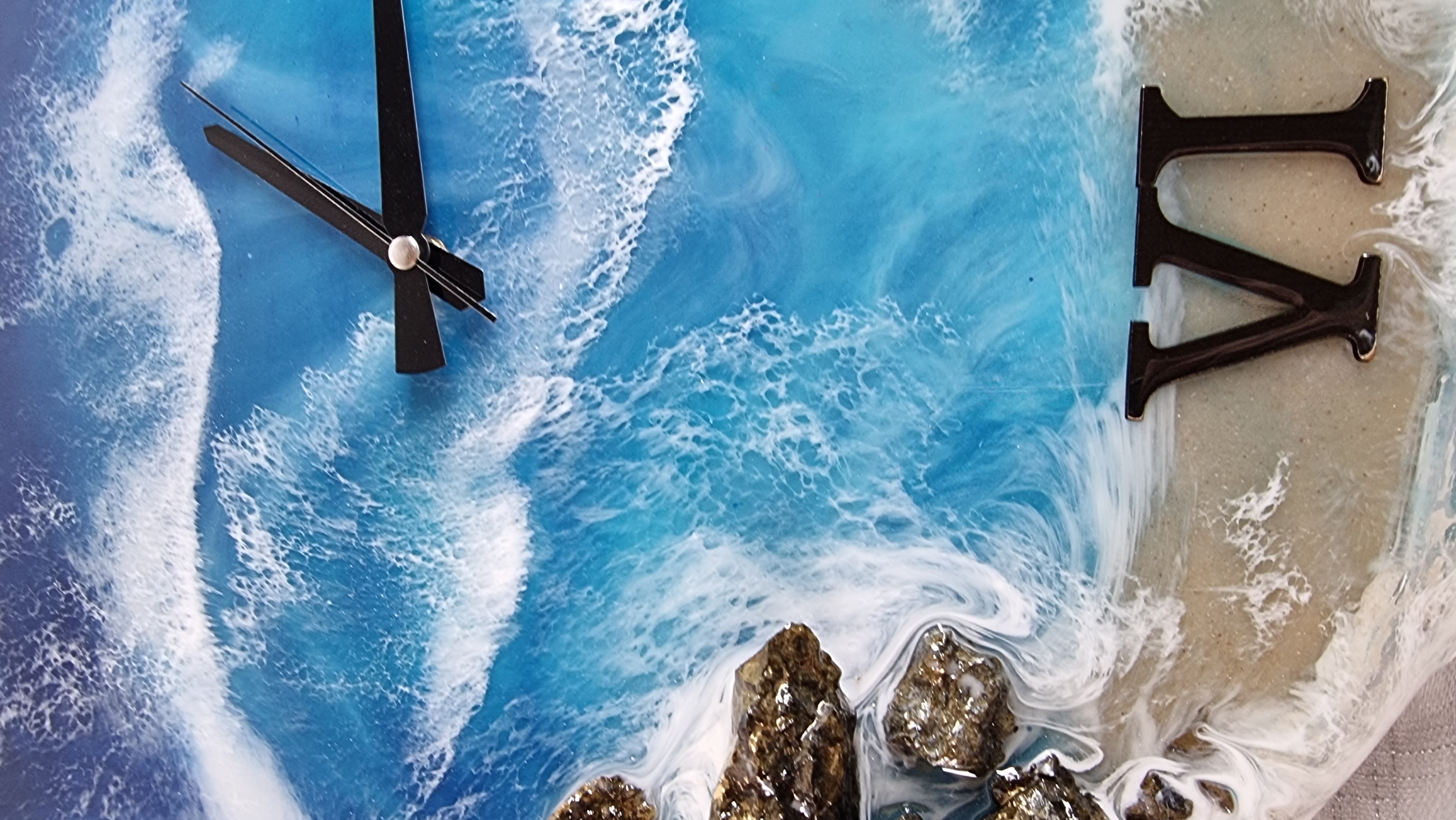 Sea-themed epoxy-resin coated clock featuring a sandy beach surrounded by rocks. Diameter: 50 cm.