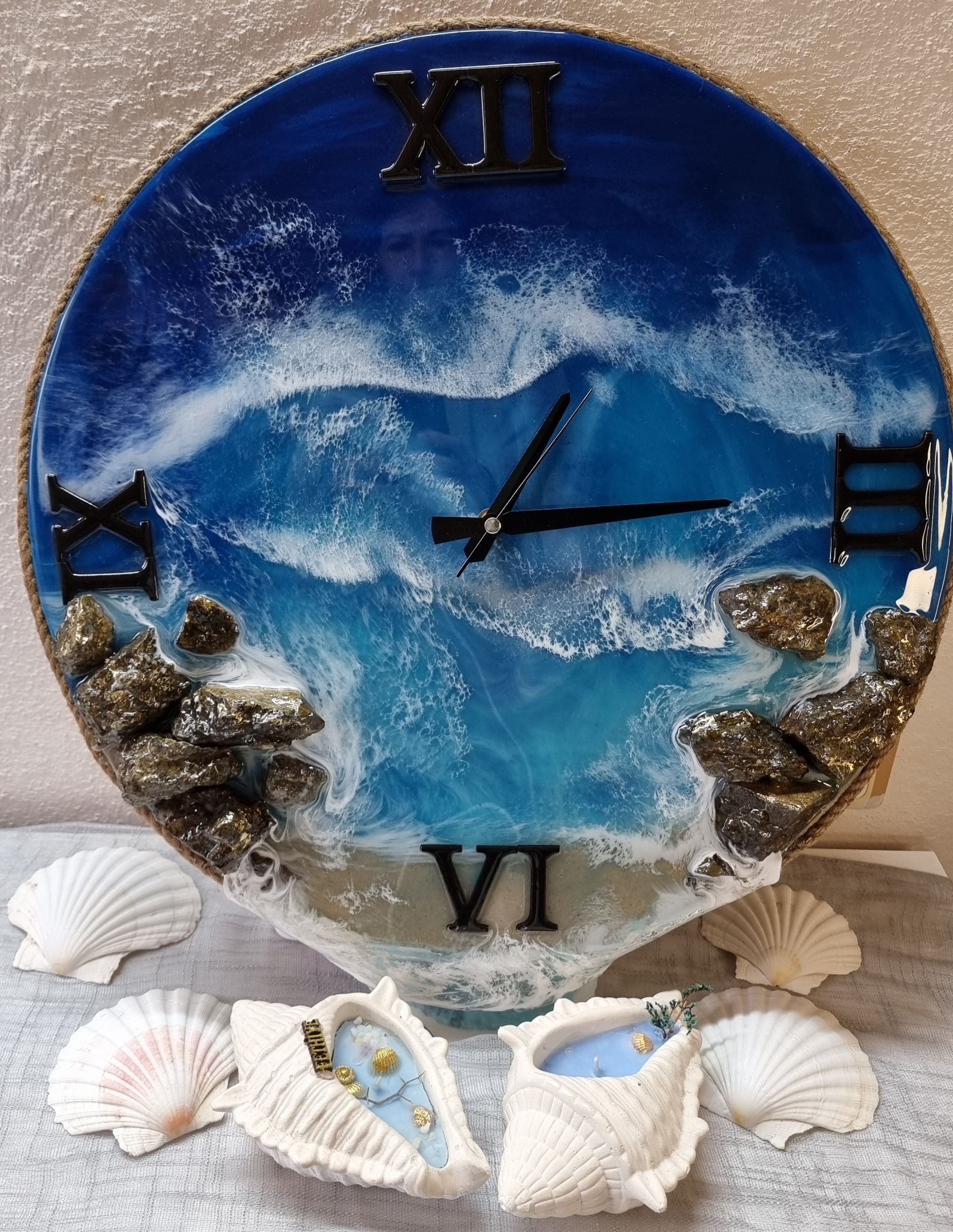 Sea-themed epoxy-resin coated clock featuring a sandy beach surrounded by rocks. Diameter: 50 cm.