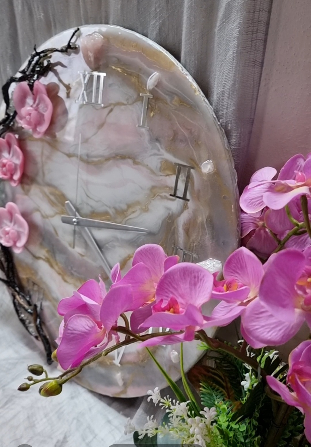 Pink epoxy-resin coated clock featuring orchids, driftwood and Roman numbers. Size (diameter) ranges from 14 to 23,8 inches. 