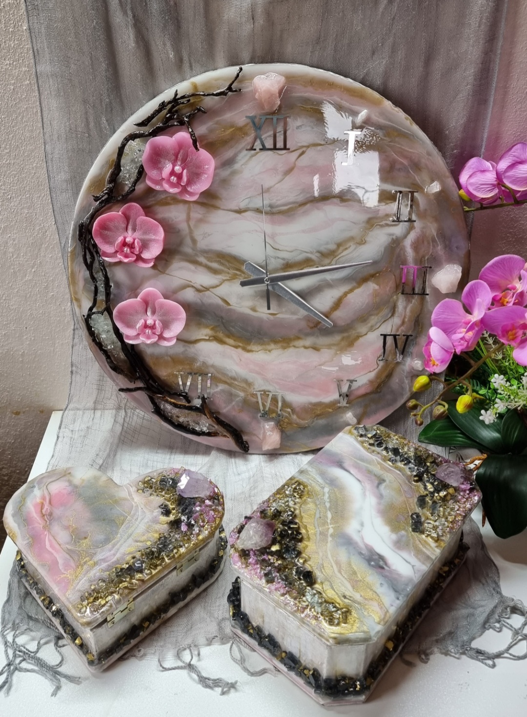 Pink epoxy-resin coated clock featuring orchids, driftwood and Roman numbers. Size (diameter) ranges from 14 to 23,8 inches. 