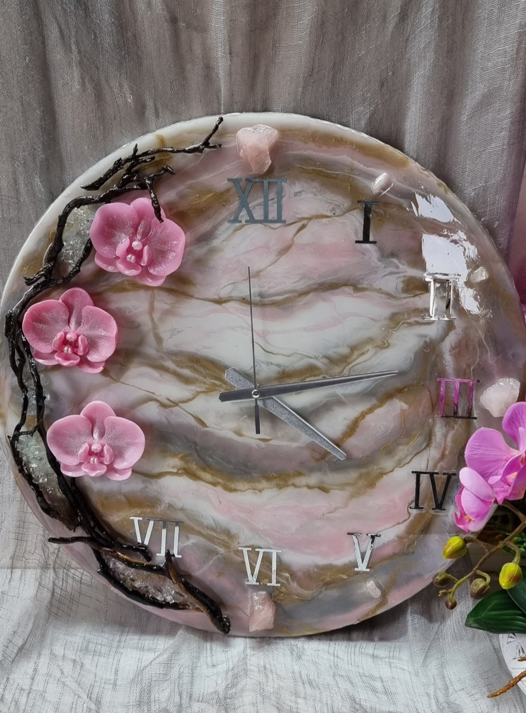 Pink epoxy-resin coated clock featuring orchids, driftwood and Roman numbers. Size (diameter) ranges from 14 to 23,8 inches.