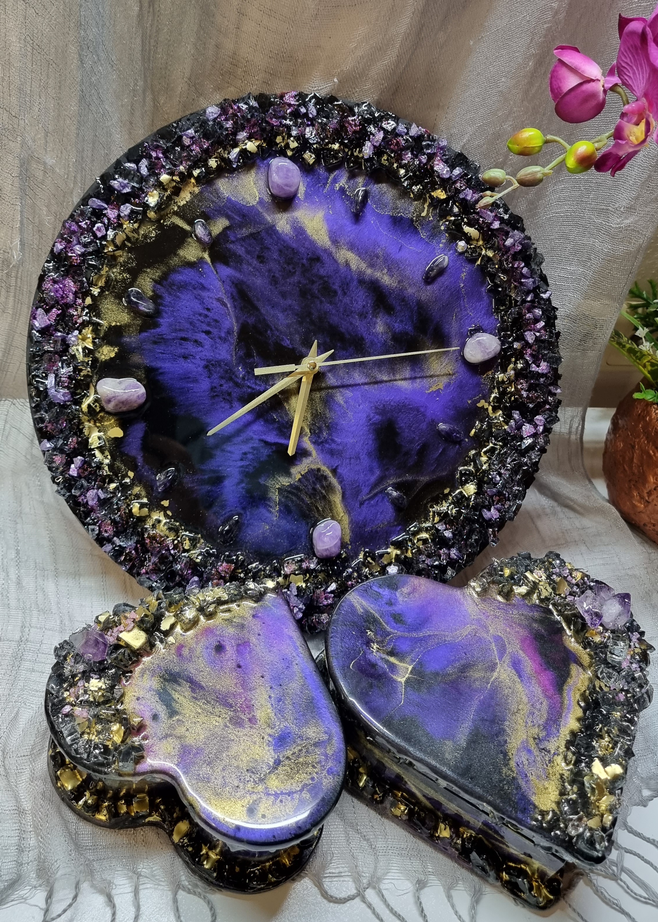 Dark-purple-coloured epoxy-resin coated wall clock featuring natural amethysts. Diameters range from 14 to 23,8 inches. 