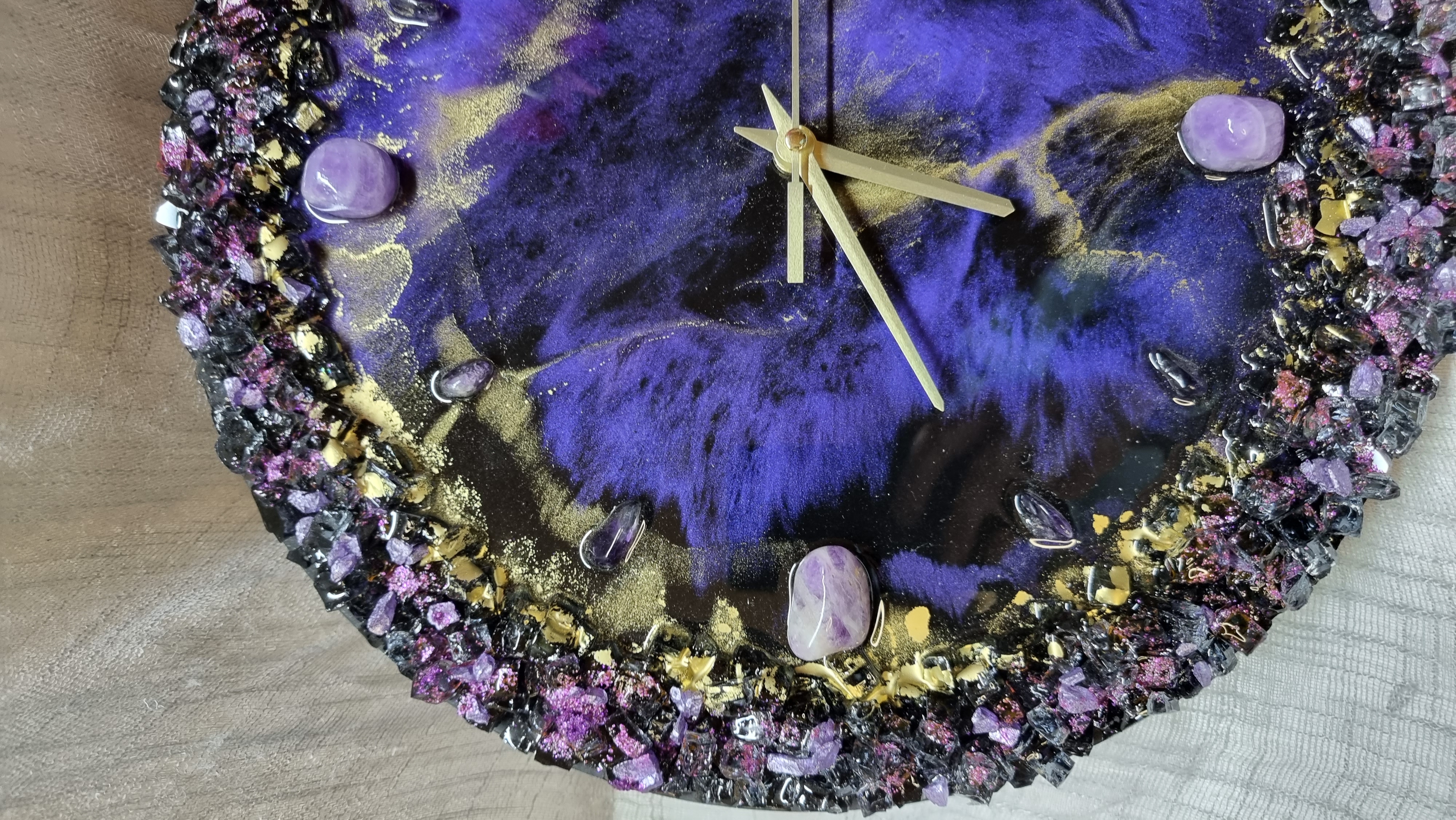 Dark-purple-coloured epoxy-resin coated wall clock featuring natural amethysts. Diameters range from 14 to 23,8 inches. 