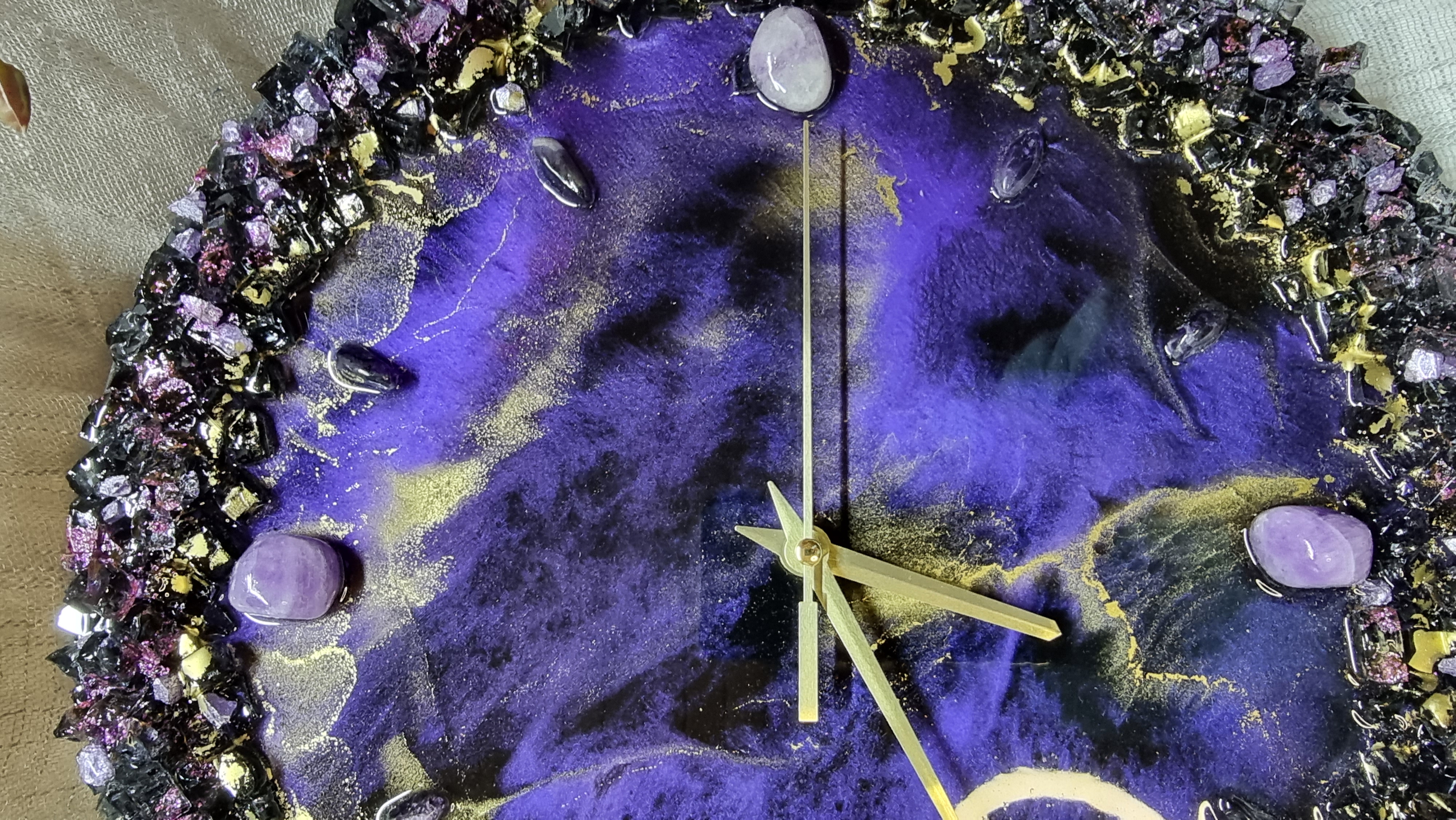 Dark-purple-coloured epoxy-resin coated wall clock featuring natural amethysts. Diameters range from 14 to 23,8 inches. 