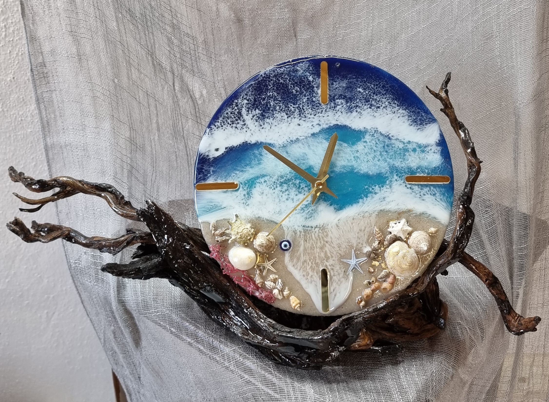 Sea-themed epoxy-resin coated table-top clock mounted on varnished driftwood. Diameter: 20 cm.