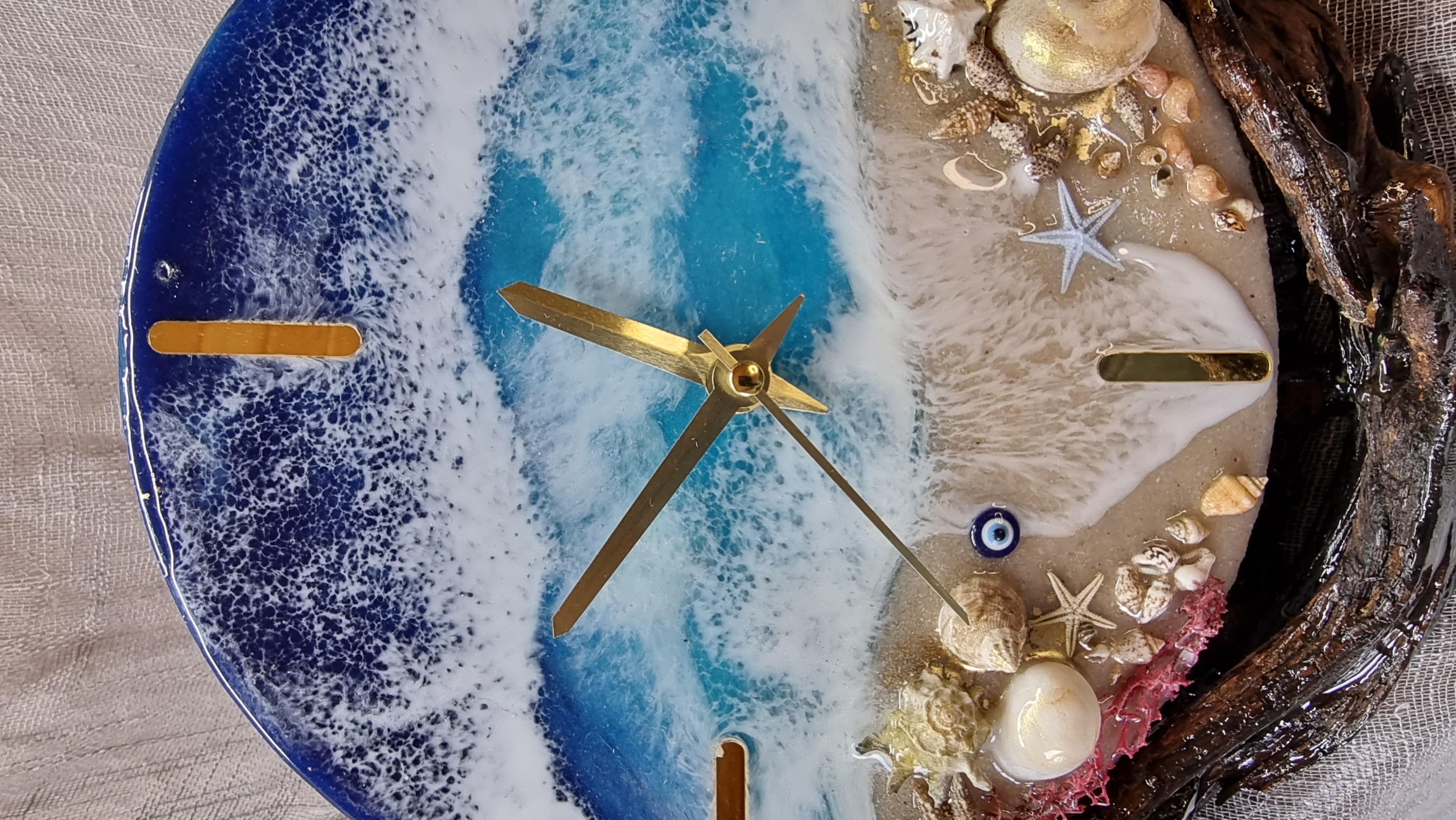 Sea-themed epoxy-resin coated table-top clock mounted on varnished driftwood. Diameter: 20 cm.