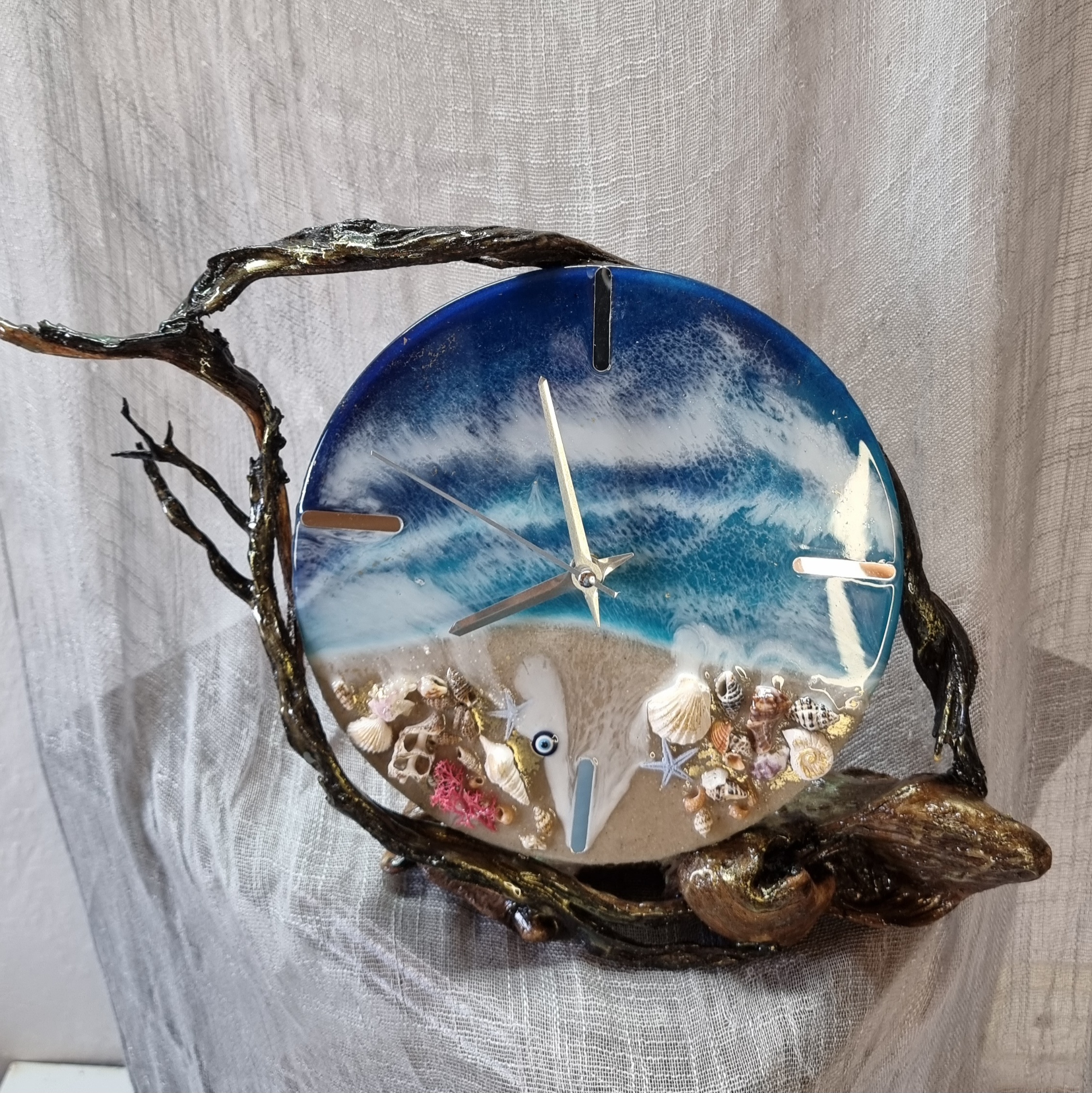 Sea-themed epoxy-resin coated table-top clock mounted on varnished driftwood. Diameter: 20 cm.