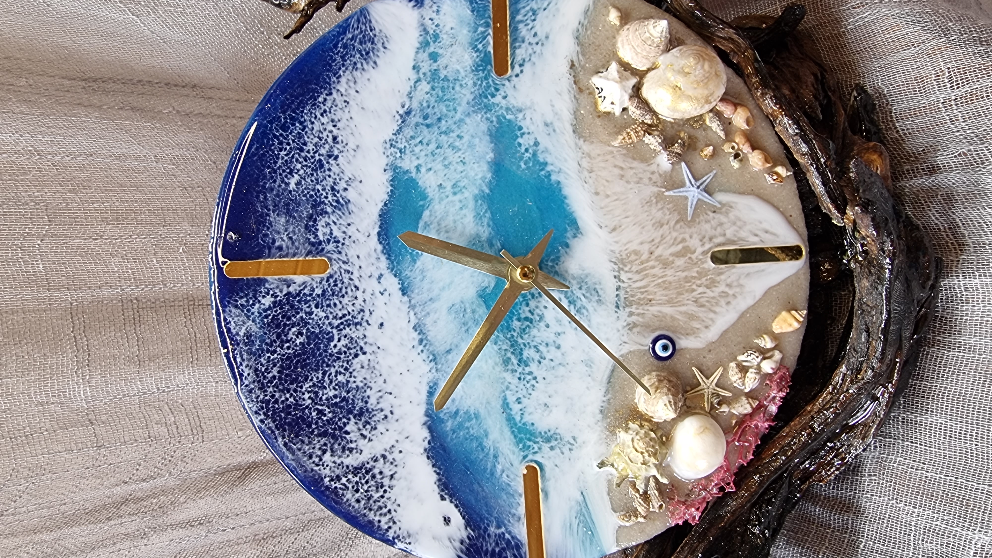 Sea-themed epoxy-resin coated table-top clock mounted on varnished driftwood. Diameter: 20 cm.