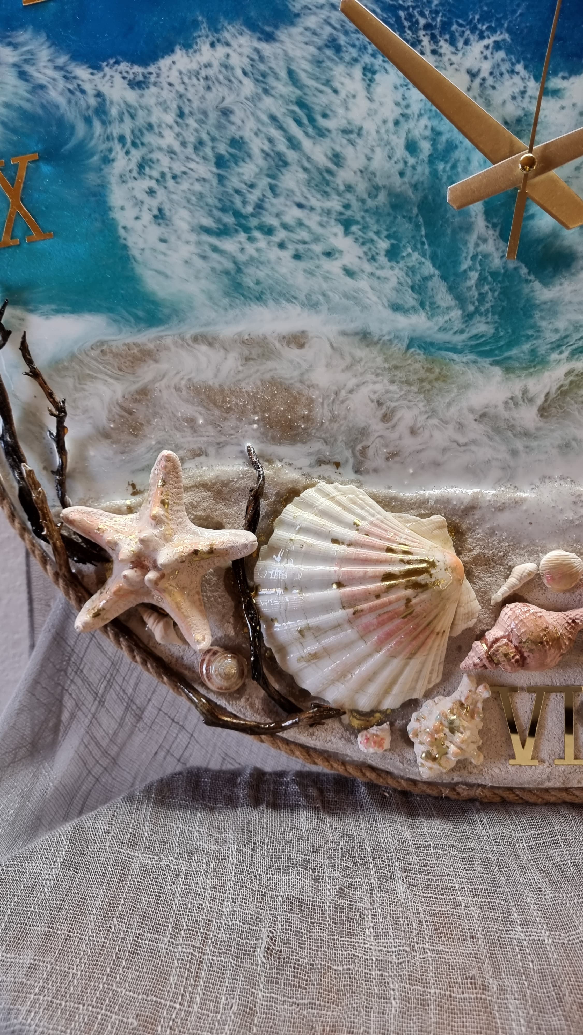 Sea-themed epoxy-resin coated clock featuring 2 fish, sea shells, starfish on a sandy beach. Diameters range from 14 to 23,8 inches. 